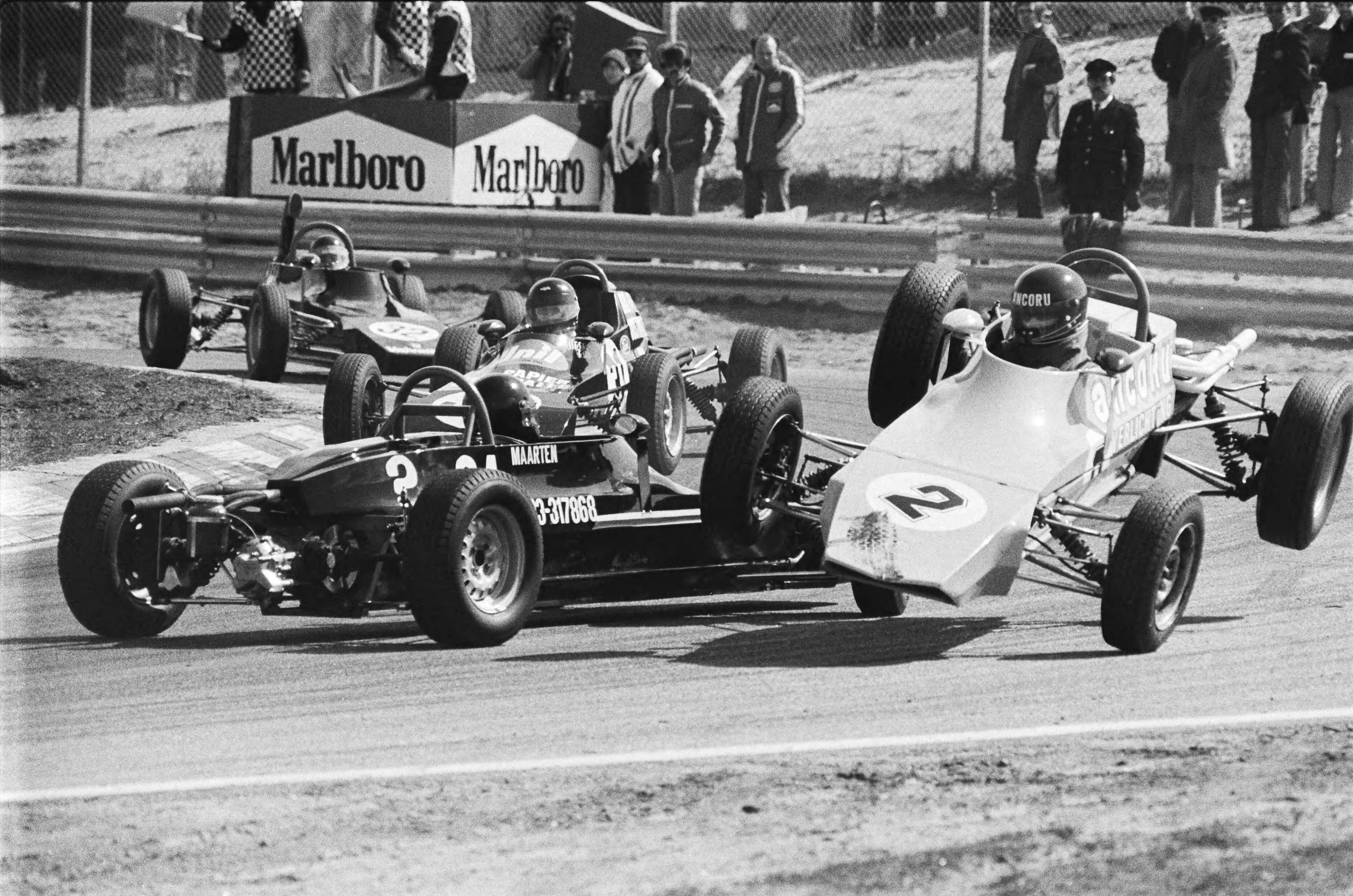 Fotocollectie Anefo — Jubileum races 30 jaar circuit Zandvoort; in de formule ford 1600 race rijdt Eric Kistemaker (2) over het wiel van de gespinde auto van Maarten Oostewaal / — Foto: Suyk, Koen / Anefo. Licentie: Set B: Rechtenvrij / Publiek Domein. Bron: Nationaal Archief. http://hdl.handle.net/10648/acb09bae-d0b4-102d-bcf8-003048976d84