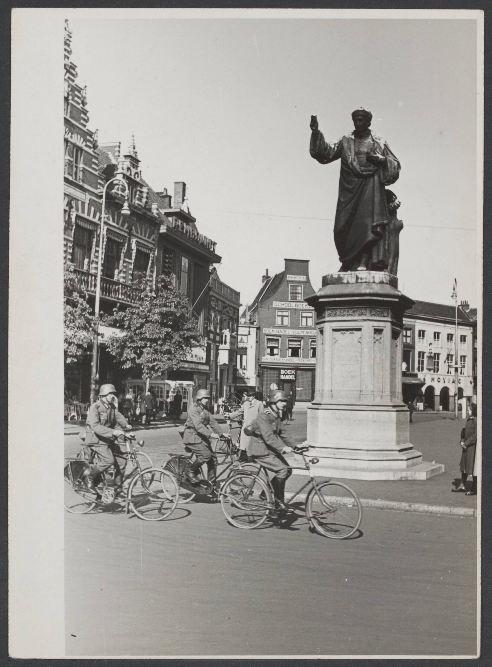 De bezetter, de bezetting in Nederland, het persoonsbewijs — Duitse militairen op de fiets op de Grote Markt te Haarlem bij het standbeeld van Laurens Jansz. Coster — Foto: Stapf Bilderdienst. Licentie: Set B: Rechtenvrij / Publiek Domein. Bron: Nationaal Archief. http://hdl.handle.net/10648/10952071-138b-adf4-5c17-89aca4092e0f