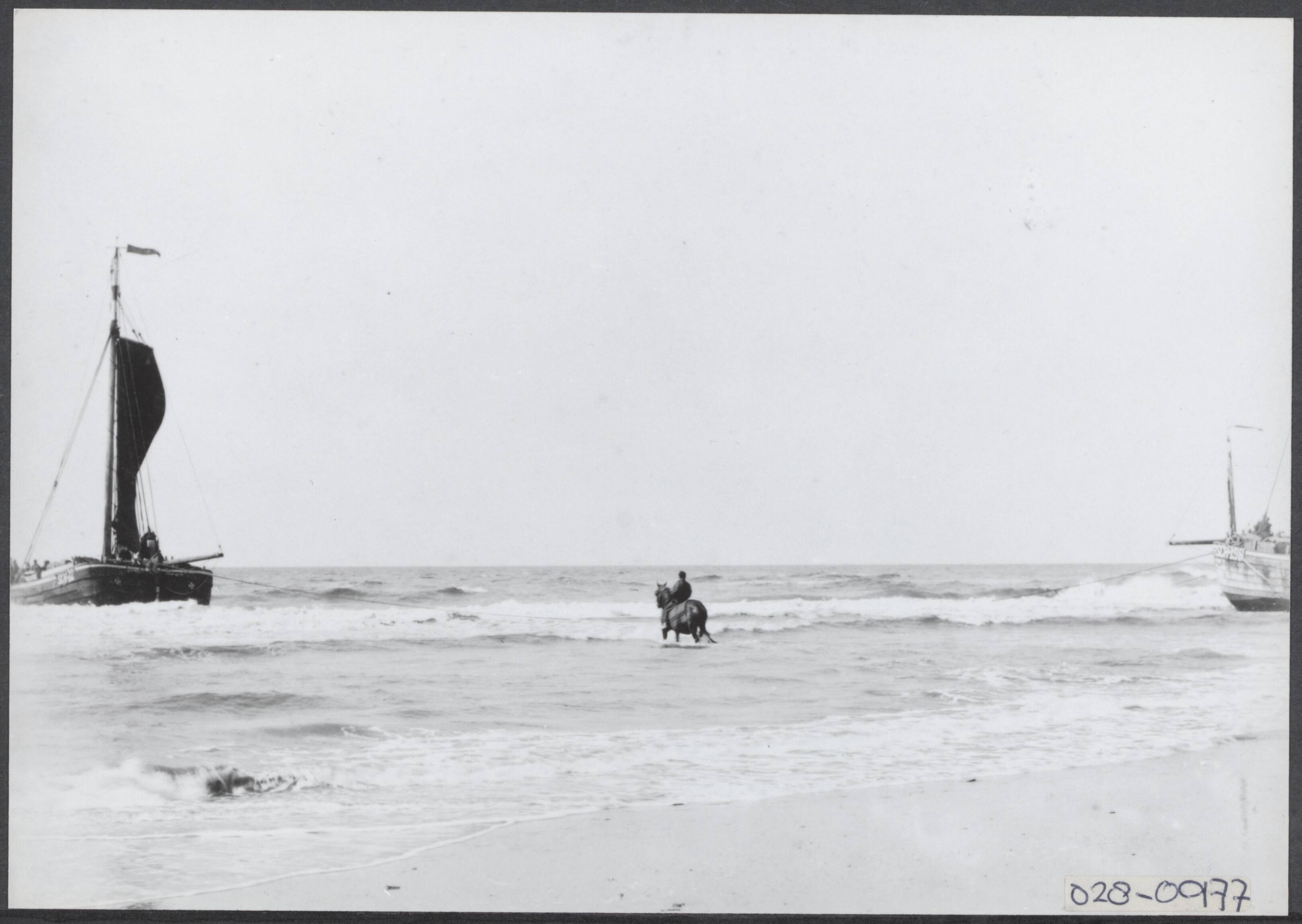 Fotocollectie Elsevier Binnenland — Scheveningen. Strand met bomschuiten en ruiter — Foto: Onbekend / Publiek Domein of Rechtenvrij. Licentie: Set B: Rechtenvrij / Publiek Domein. Bron: Nationaal Archief. http://hdl.handle.net/10648/addf6942-d0b4-102d-bcf8-003048976d84