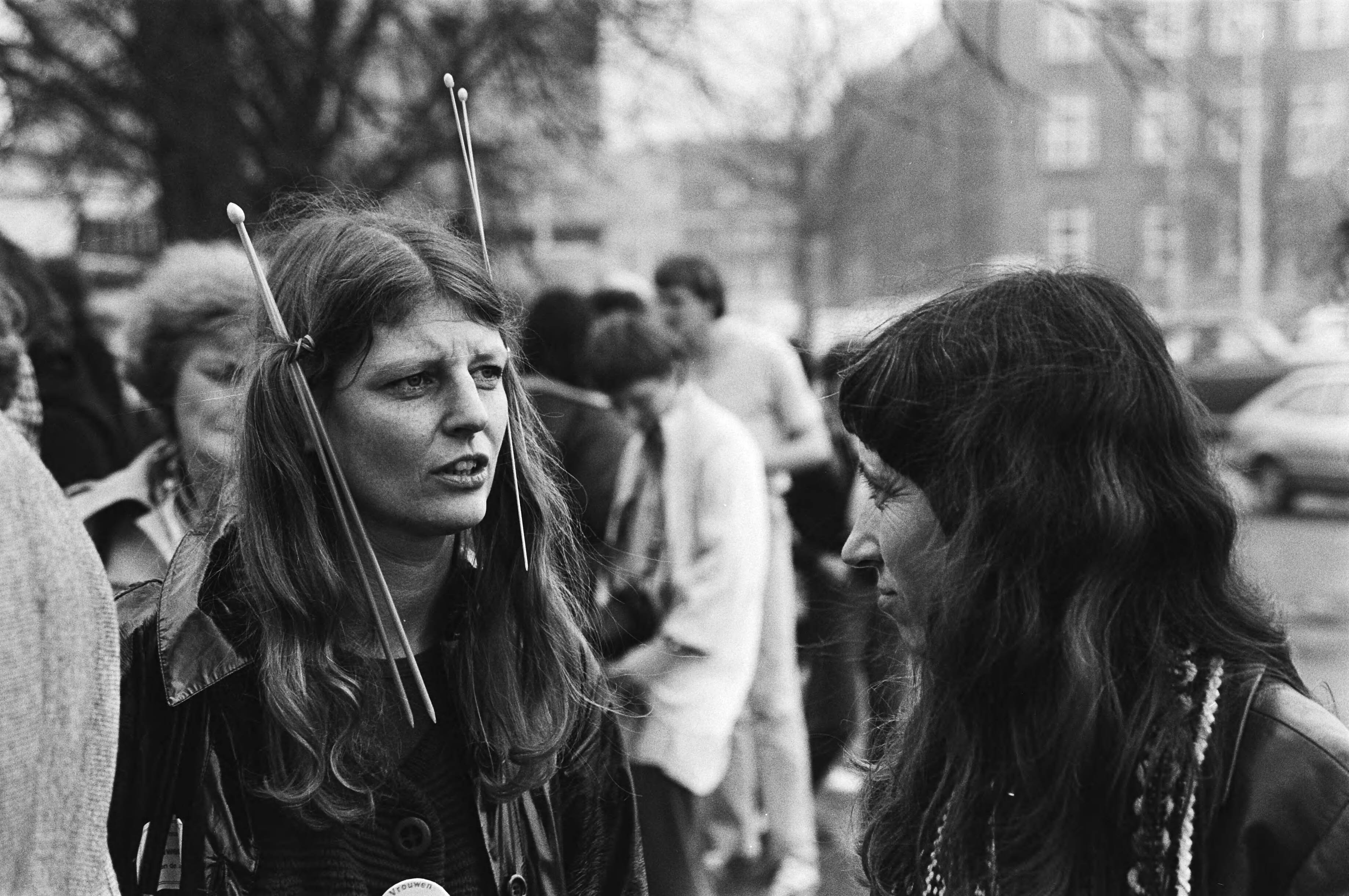 Fotocollectie Anefo — Landelijke vrouwenstakingsdag, in Den Haag werd i.v.m. landelijke vrouwenstakingsdag dem., met breinaalden in haar — Foto: Dijk, Hans van / Anefo. Licentie: Set B: Rechtenvrij / Publiek Domein. Bron: Nationaal Archief. http://hdl.handle.net/10648/acf8495e-d0b4-102d-bcf8-003048976d84