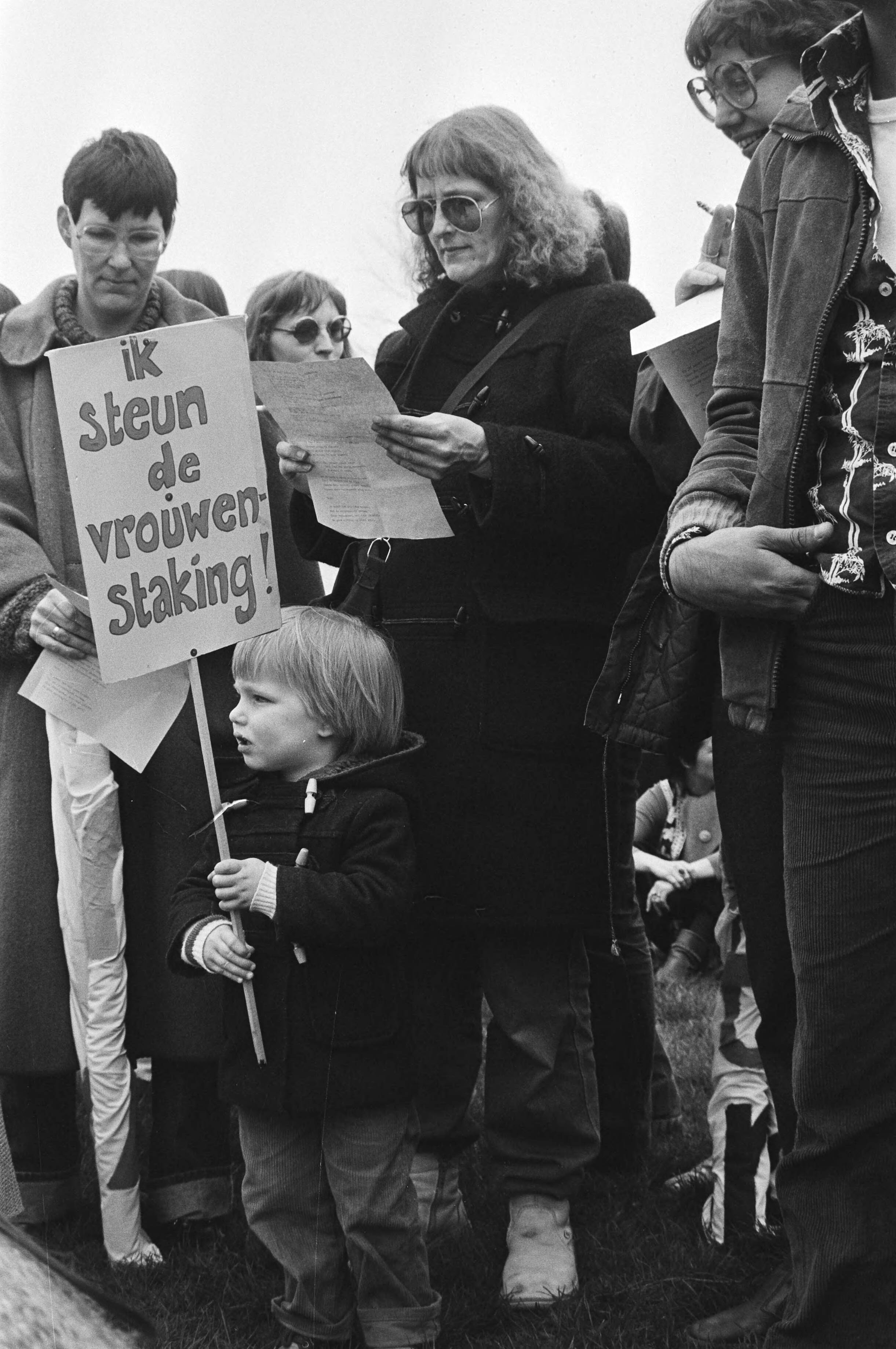 Fotocollectie Anefo — Landelijke vrouwenstakingsdag, in Den Haag werd i.v.m. landelijke vrouwenstakingsdag dem. , kind met stakingsbord tussen — Foto: Dijk, Hans van / Anefo. Licentie: Set B: Rechtenvrij / Publiek Domein. Bron: Nationaal Archief. http://hdl.handle.net/10648/acf8467a-d0b4-102d-bcf8-003048976d84