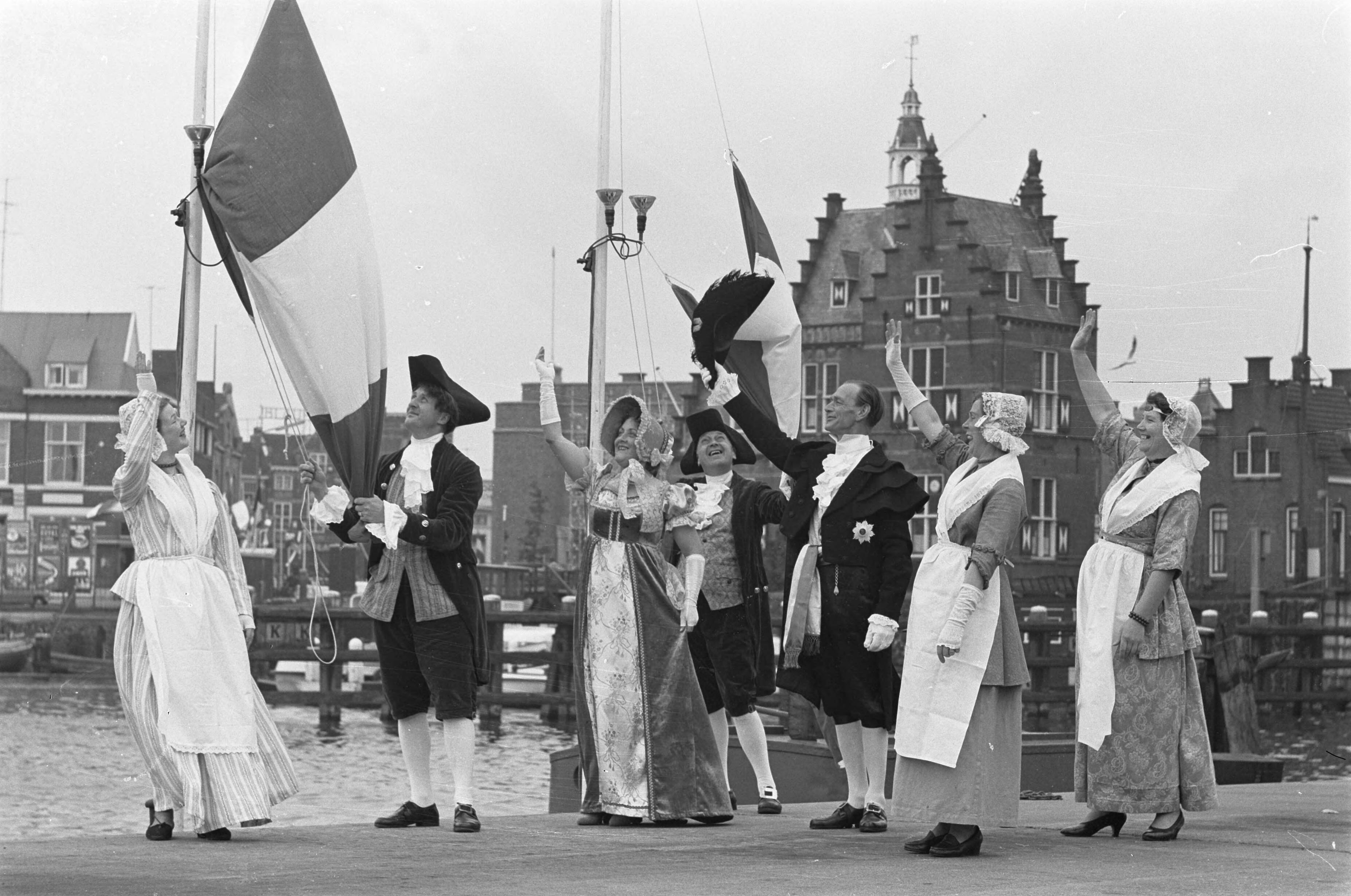 Fotocollectie Anefo — Zaandam 150 jaar stad. Zaandammers in historische kostuums. Vlaggen worden opgehesen — Foto: Pot, Harry / Anefo. Licentie: Set B: Rechtenvrij / Publiek Domein. Bron: Nationaal Archief. http://hdl.handle.net/10648/a9d857dc-d0b4-102d-bcf8-003048976d84