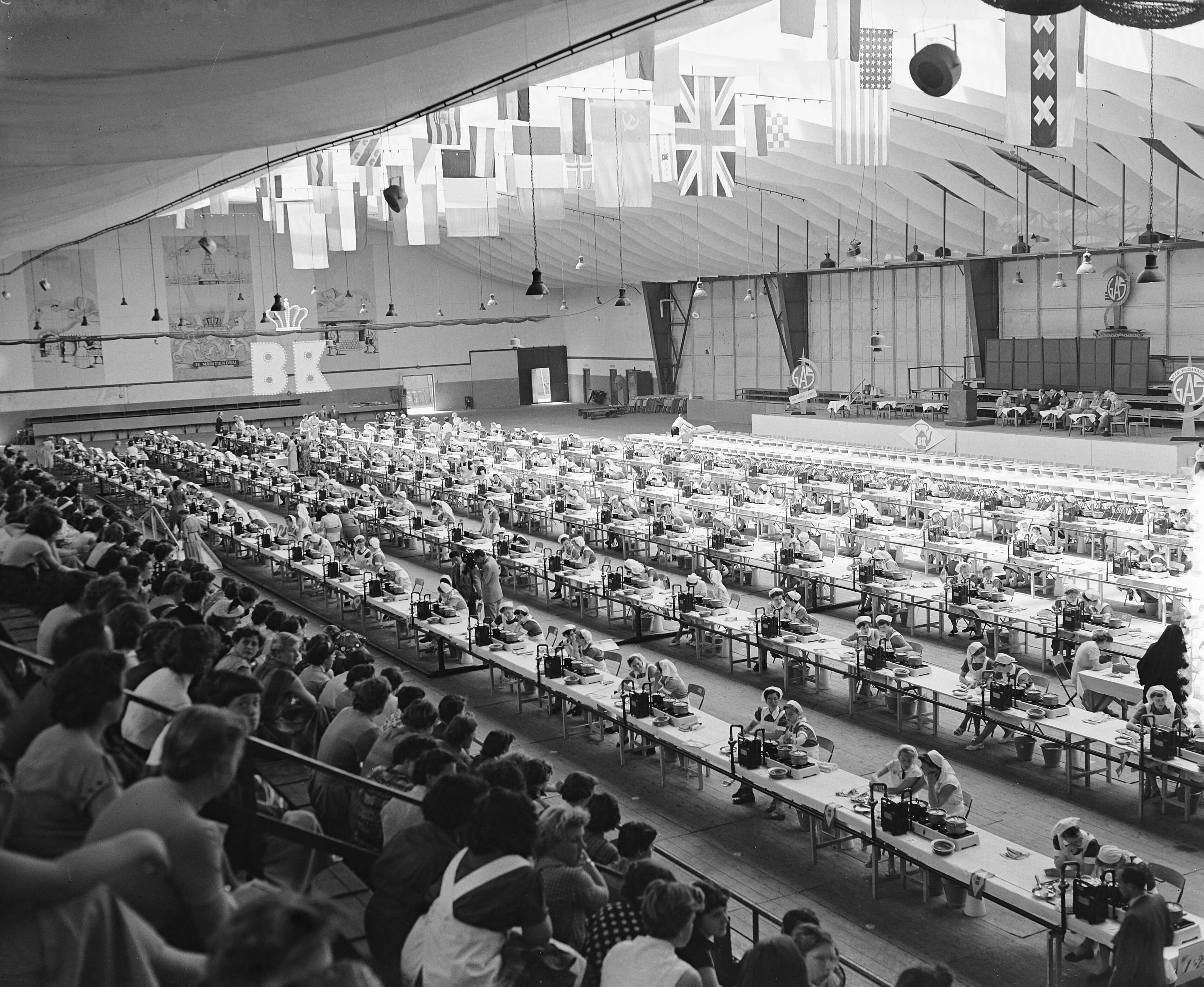 Fotocollectie Anefo — B. K. Kookwedstrijd in de Houtrusthallen te Den Haag — Foto: Rossem, Wim van / Anefo. Licentie: Set B: Rechtenvrij / Publiek Domein. Bron: Nationaal Archief. http://hdl.handle.net/10648/a921d368-d0b4-102d-bcf8-003048976d84