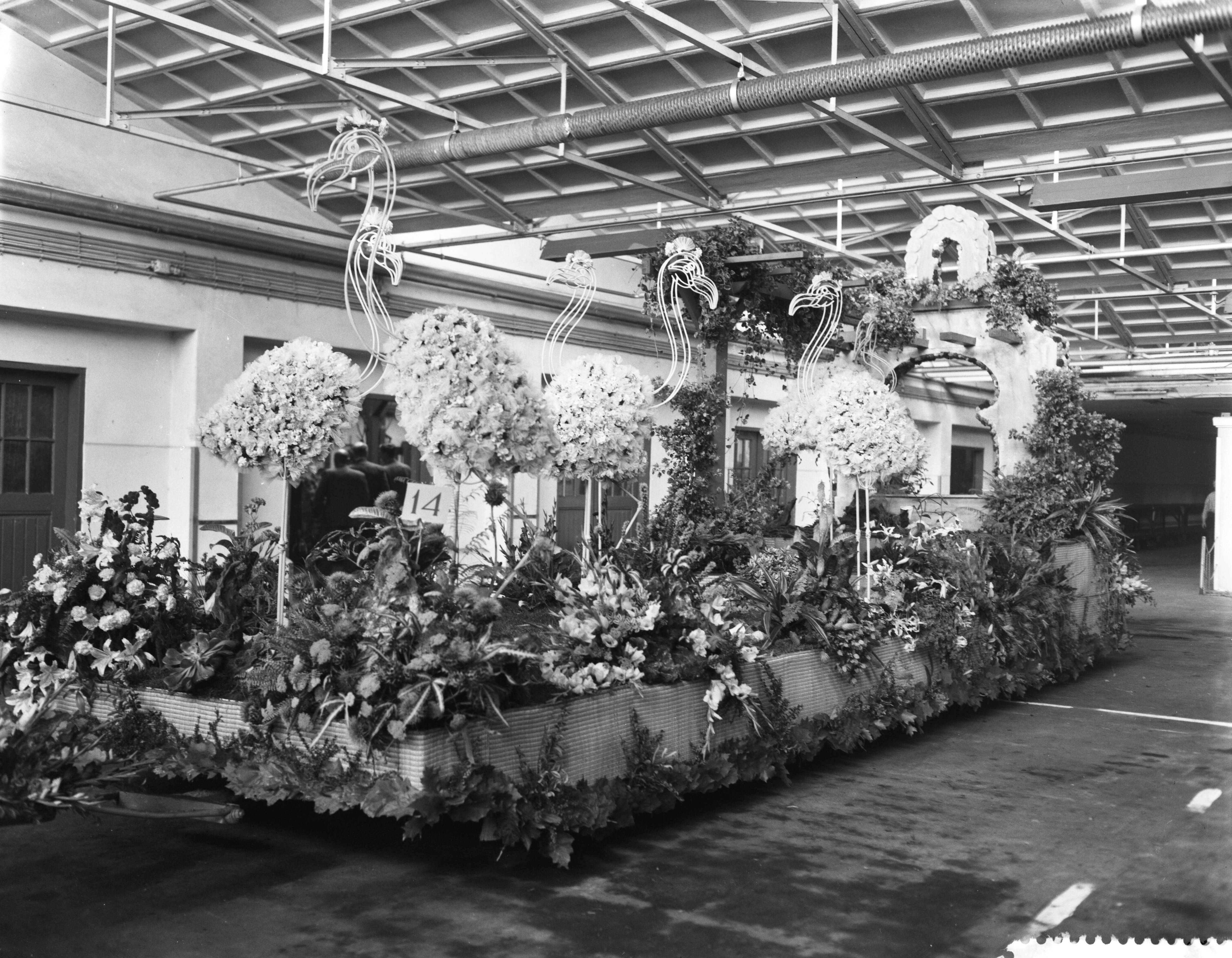 Fotocollectie Anefo — Praalwagens worden opgesierd in de Aalsmeerder veilinghallen voor het bloemencorso — Foto: Bilsen, Joop van / Anefo. Licentie: Set B: Rechtenvrij / Publiek Domein. Bron: Nationaal Archief. http://hdl.handle.net/10648/a9b84726-d0b4-102d-bcf8-003048976d84