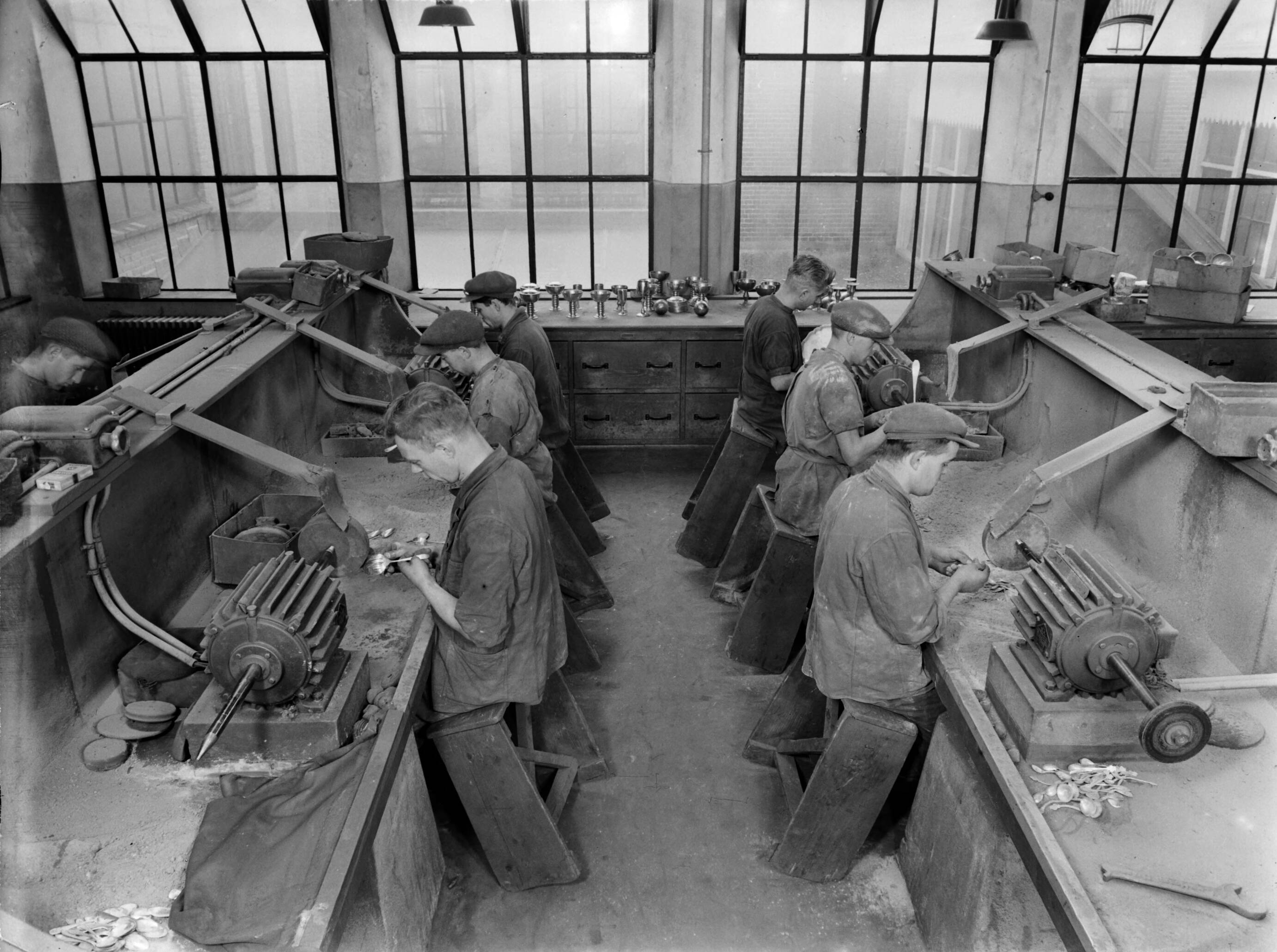 Productfoto's; zilverwerk — Met behulp van slijpmachines nabewerken van zilveren producten bij de fa. Gerritsen & Van Kempen in Zeist — Foto: Poll, Willem van de. Licentie: Set B: Rechtenvrij / Publiek Domein. Bron: Nationaal Archief. http://hdl.handle.net/10648/ae9e425e-d0b4-102d-bcf8-003048976d84
