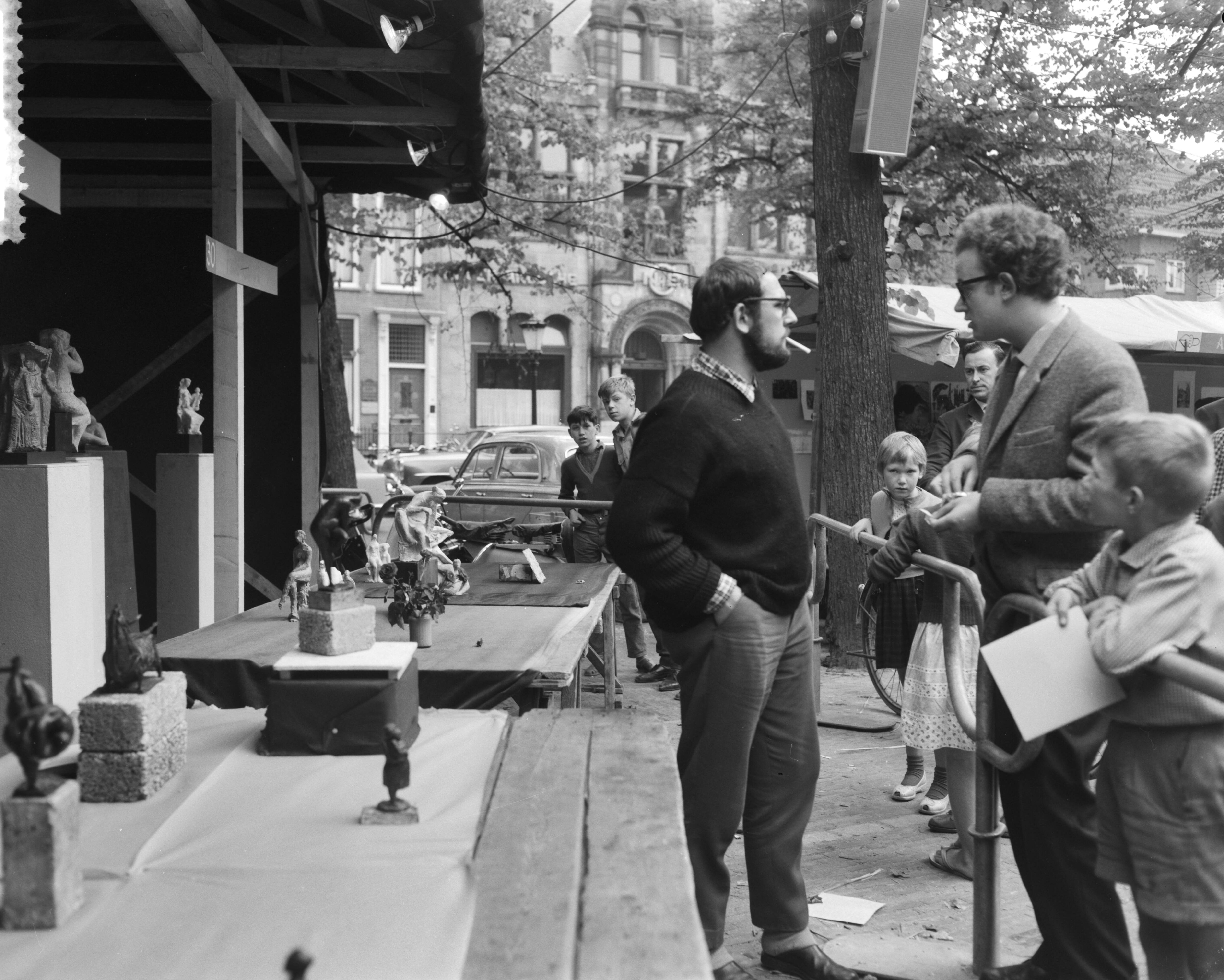 Fotocollectie Anefo — Kunstenaarsmanifestatie op het Janskerkhof te Utrecht. Een beeldhouwer bij zijn stand — Foto: Bilsen, Joop van / Anefo. Licentie: Set B: Rechtenvrij / Publiek Domein. Bron: Nationaal Archief. http://hdl.handle.net/10648/a9b8cad4-d0b4-102d-bcf8-003048976d84
