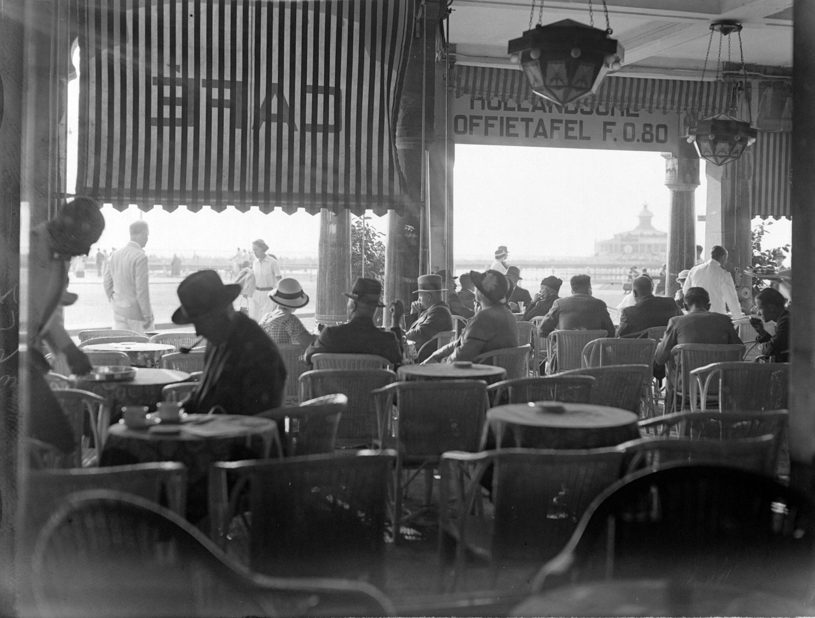 Scheveningen. — Een café aan de boulevard in Scheveningen — Foto: Poll, Willem van de. Licentie: Set B: Rechtenvrij / Publiek Domein. Bron: Nationaal Archief. http://hdl.handle.net/10648/ae9acf34-d0b4-102d-bcf8-003048976d84
