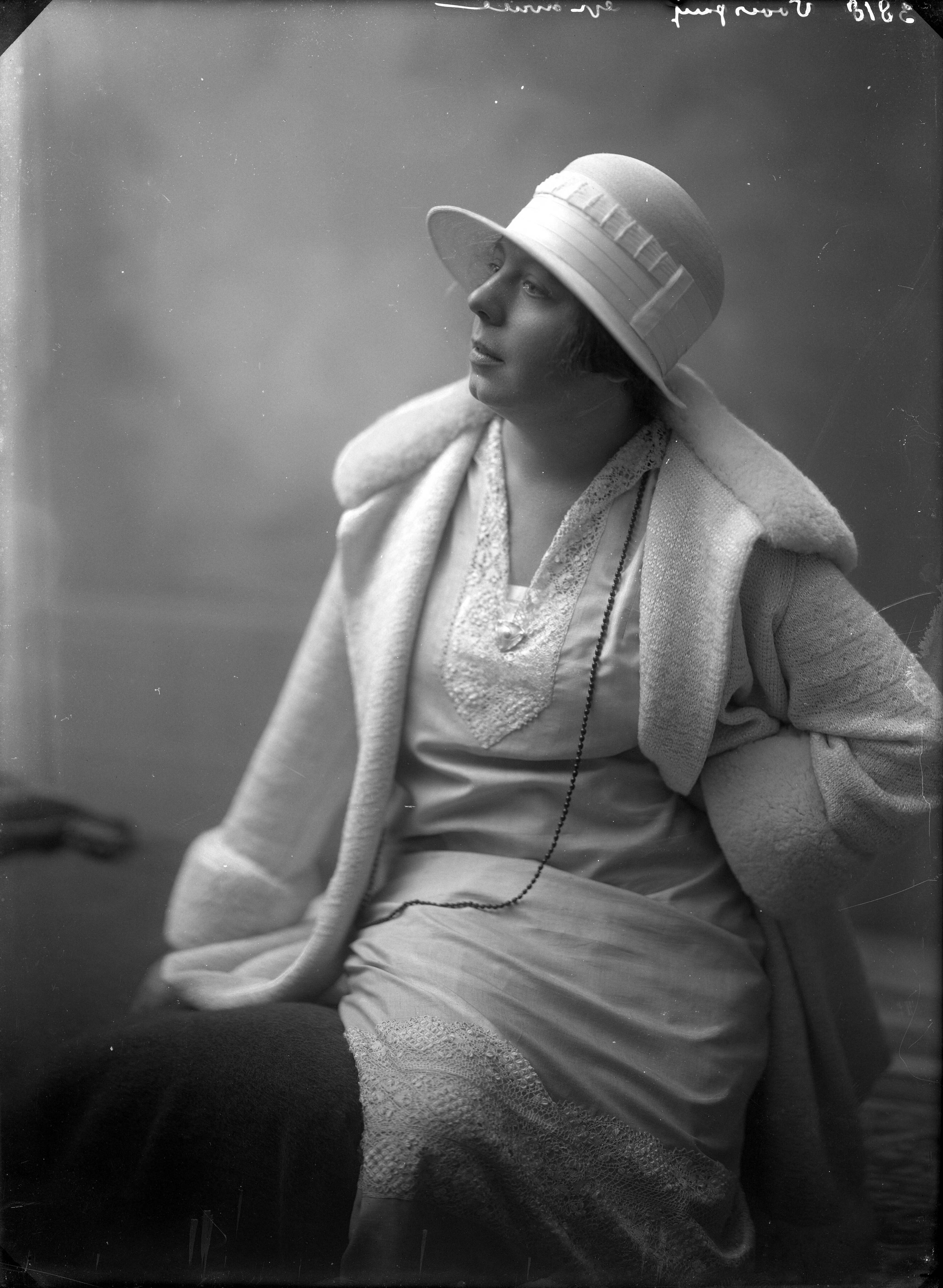 Portretten — Studio-opnames. Portret van een vrouw geheel gekleed in het wit, een jurk met kanten halsinzet, wijde wollen jas met bontkraag en manchetten, een grote witte vilten hoed. Haarlem, Nederland. 1918-1930. 3813 Voois-? gravure — Foto: Berg, Th.C.J. van den / Spaarnestad Photo (05887). Licentie: Set B: Rechtenvrij / Publiek Domein. Bron: Nationaal Archief. http://hdl.handle.net/10648/35429da7-c620-a382-e063-6df0900a6686