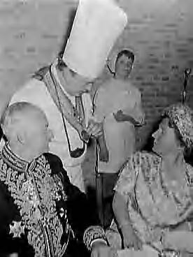 Bezoek van koningin Juliana aan Middelburg en Katseveer (1960) — Koningin Juliana bezoekt Middelburg; Koningin tijdens de lunch, De Vlaamse rotisseur Noël Desloovere toont haar zijn culinaire onderscheidingen. Links de gouverneur van de Belgische koning in Oost-Vlaanderen A. Mariën — Foto: Rossem, Wim van / Anefo. Licentie: Set B: Rechtenvrij / Publiek Domein. Bron: Nationaal Archief. http://hdl.handle.net/10648/a9aeefc8-d0b4-102d-bcf8-003048976d84