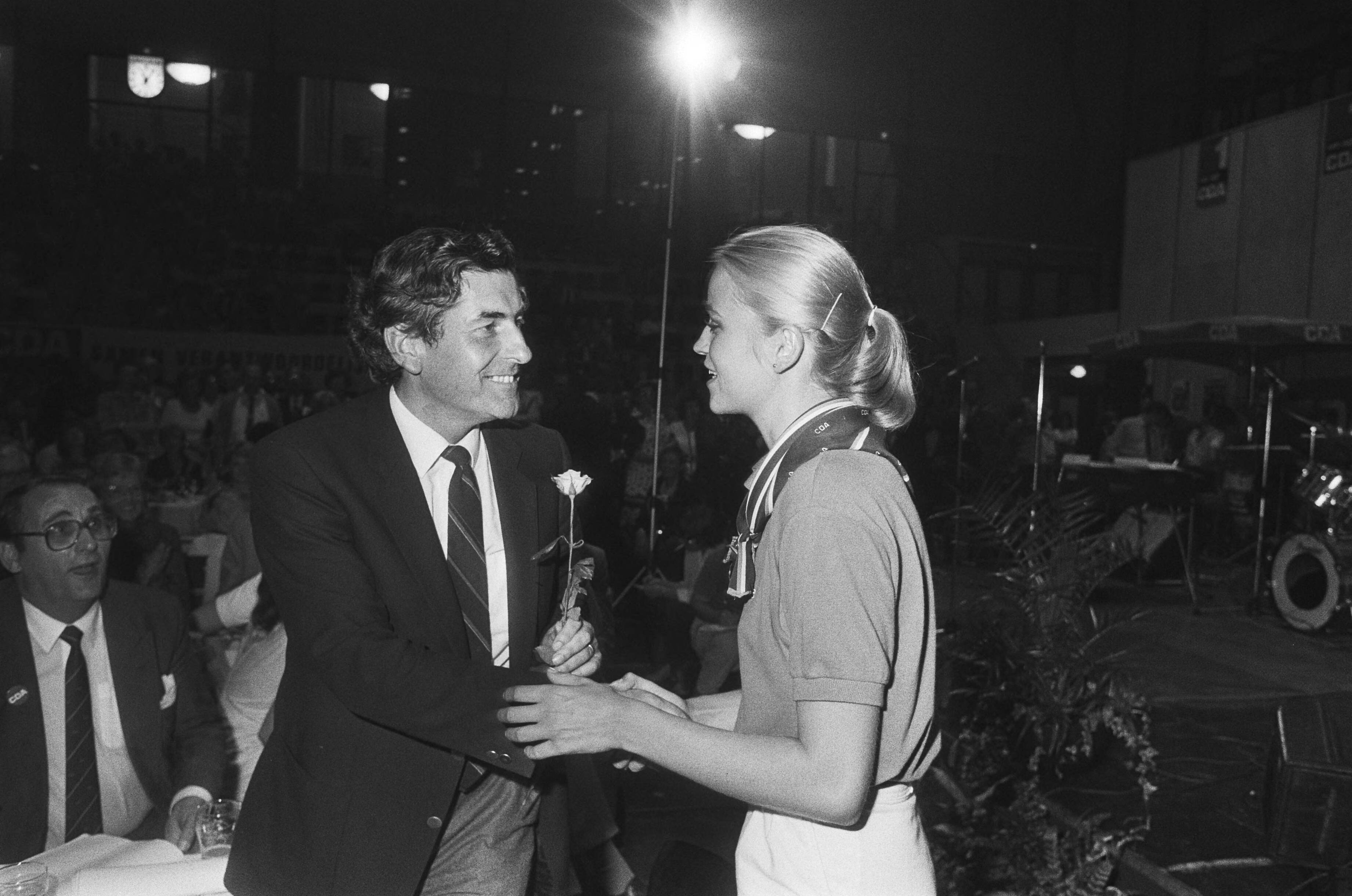 Fotocollectie Anefo — Tevens opdracht CDA, verkiezingsbijeenkomst CDA in Kerkrade Ruud Lubbers krijgt bloem — Foto: Bogaerts, Rob / Anefo. Licentie: Set B: Rechtenvrij / Publiek Domein. Bron: Nationaal Archief. http://hdl.handle.net/10648/ad1dce04-d0b4-102d-bcf8-003048976d84