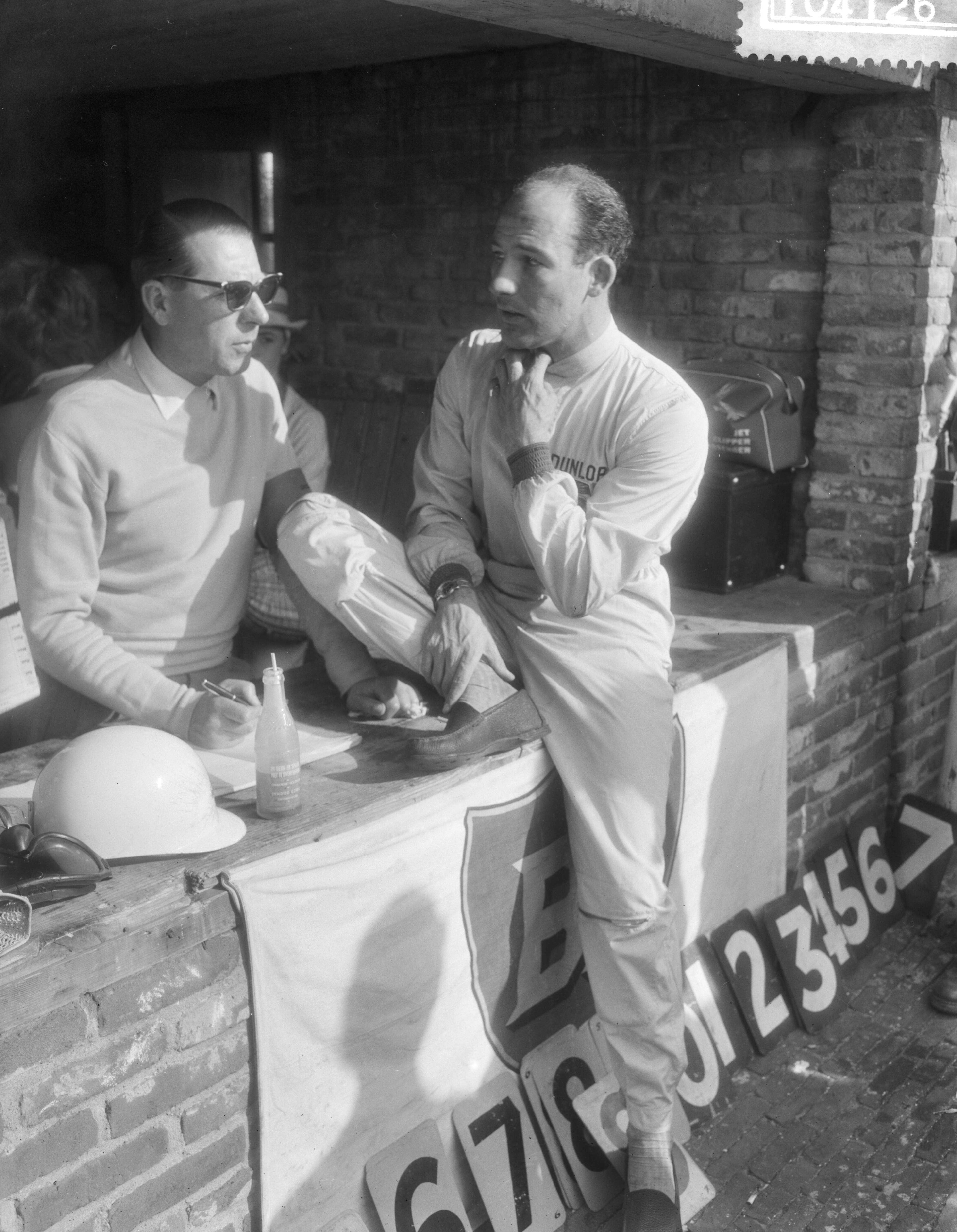 Grand Prix Zandvoort 1959 — Grand Prix van Nederland op het circuit van Zandvoort. Stirling Moss, nadat hij uitgevallen is — Foto: Pot, Harry / Anefo. Licentie: Set B: Rechtenvrij / Publiek Domein. Bron: Nationaal Archief. http://hdl.handle.net/10648/a9953290-d0b4-102d-bcf8-003048976d84