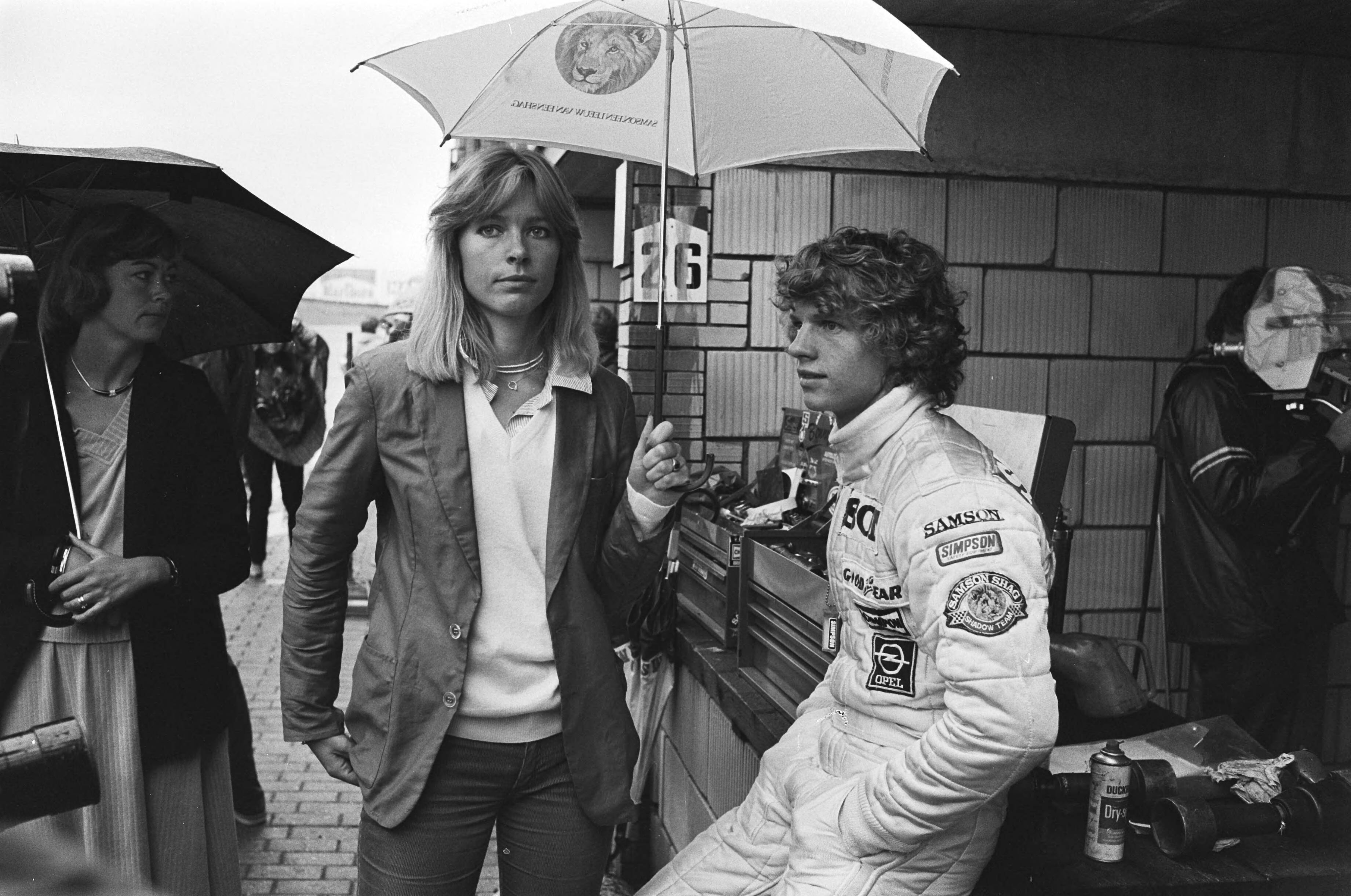 Grand Prix Zandvoort 1979, eerste training — Meisje houdt paraplu boven het hoofd van Jan Lammers — Foto: Suyk, Koen / Anefo. Licentie: Set B: Rechtenvrij / Publiek Domein. Bron: Nationaal Archief. http://hdl.handle.net/10648/accfb0ca-d0b4-102d-bcf8-003048976d84