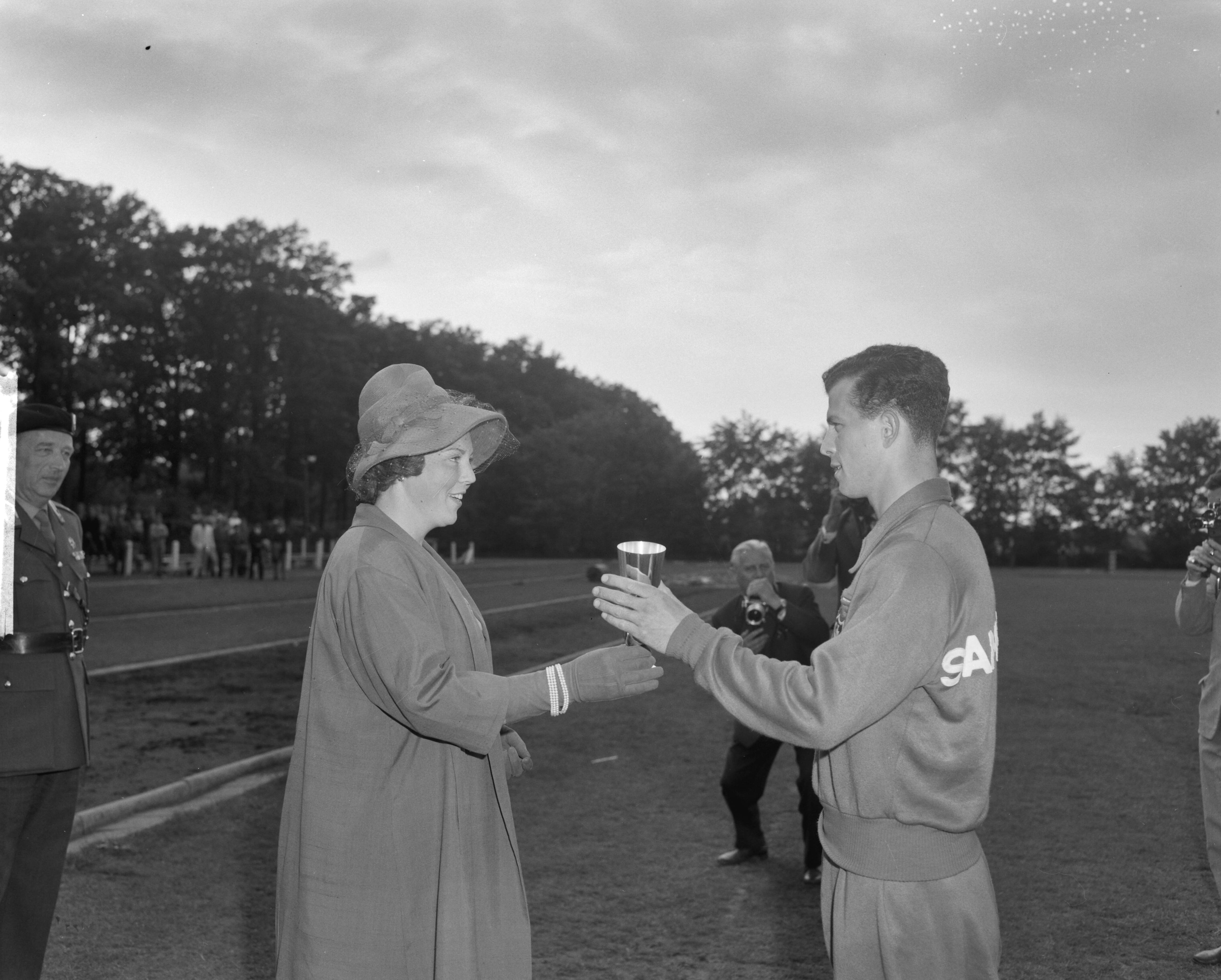 Fotocollectie Anefo — West-Europese kadetten-atletiekwedstrijden in Breda. Prinses Beatrix reikt, in plaats van prins Bernhard, een beker uit — Foto: Bilsen, Joop van / Anefo. Licentie: Set B: Rechtenvrij / Publiek Domein. Bron: Nationaal Archief. http://hdl.handle.net/10648/aa0cbd60-d0b4-102d-bcf8-003048976d84