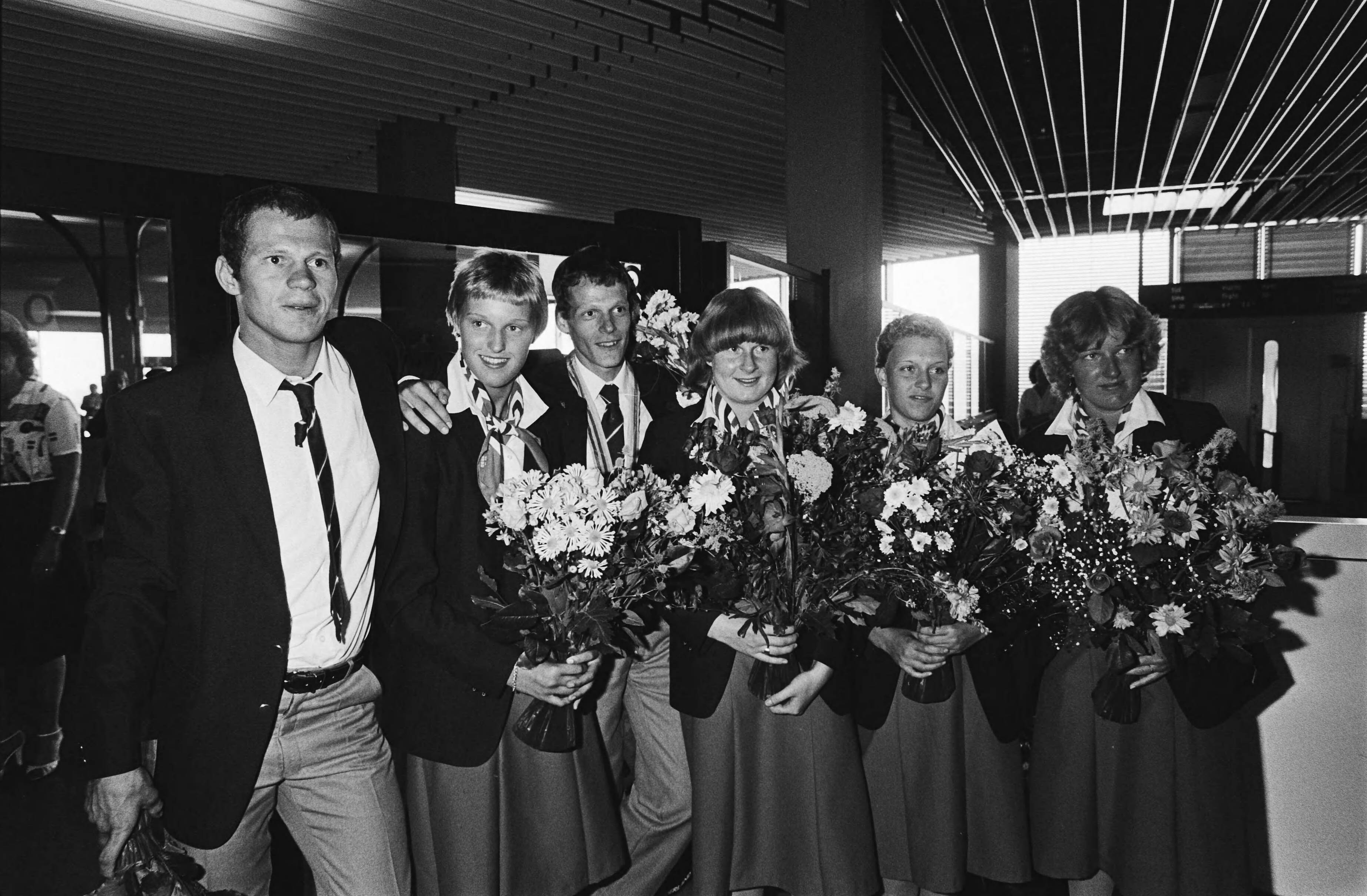 Aankomst van de Nederlandse Olympische ploeg uit Moskou op Schiphol — De medaille-winnaars : v.l.n.r. Henk Numan (judo), Conny van Bentum (zwemmen), Gerard Nijboer (marathon), Wilma van Velsen (zwemmen), Annelies Maas (zwemmen) — Foto: Dijk, Hans van / Anefo. Licentie: Set B: Rechtenvrij / Publiek Domein. Bron: Nationaal Archief. http://hdl.handle.net/10648/ace4f46c-d0b4-102d-bcf8-003048976d84