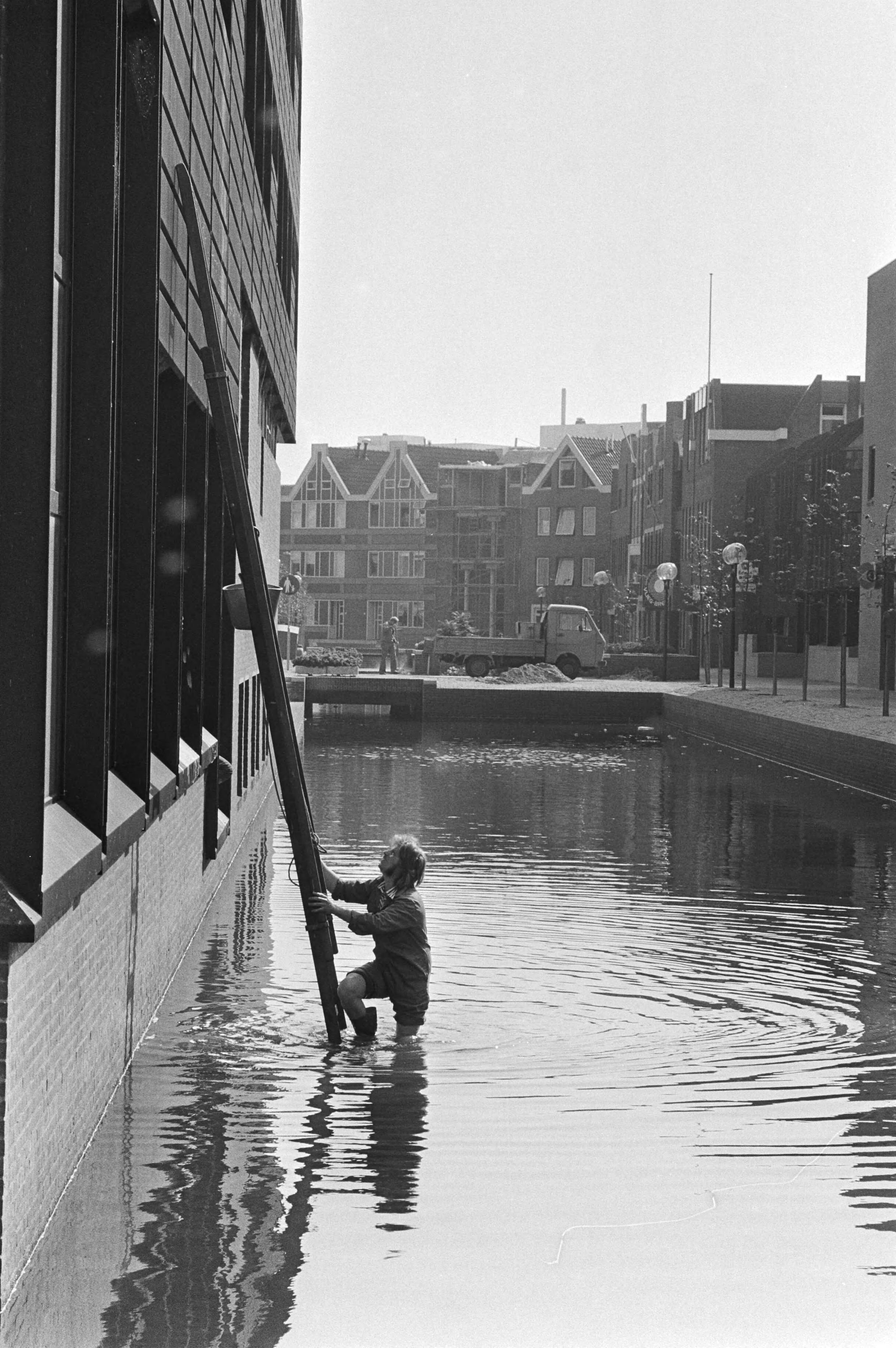 Glazenwasser met ladder in het water van het winkelcentrum in Almere Haven — Almere|Flevoland|glazenwassers |winkelcentra — Foto: Suyk, Koen / Anefo. Licentie: Set B: Rechtenvrij / Publiek Domein. Bron: Nationaal Archief. http://hdl.handle.net/10648/acd0a354-d0b4-102d-bcf8-003048976d84