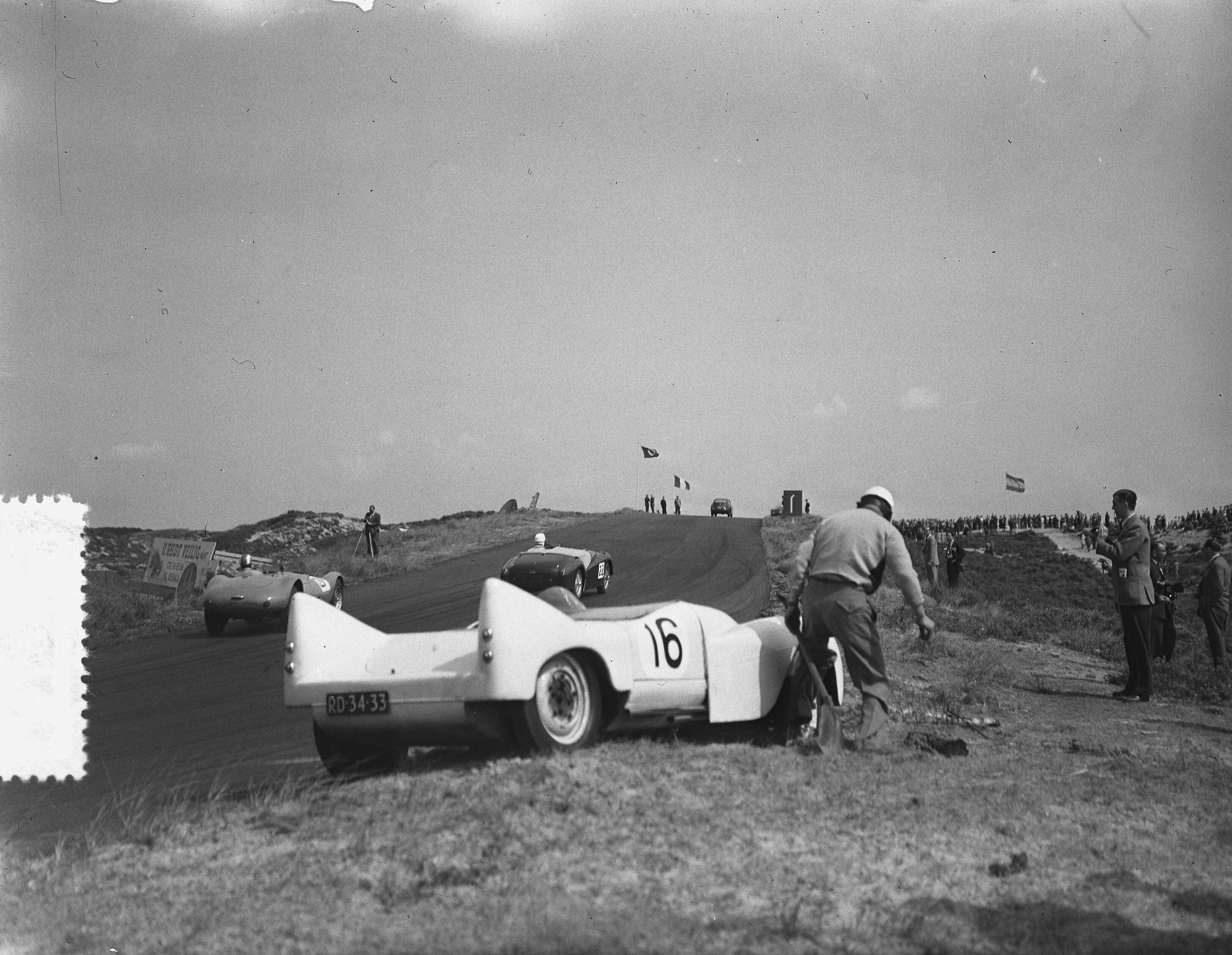 Fotocollectie Anefo — KNAC Internationale Autoraces op het circuit van Zandvoort. Auto met startnummer 16 is buiten de baan beland — Foto: Bilsen, Joop van / Anefo. Licentie: Set B: Rechtenvrij / Publiek Domein. Bron: Nationaal Archief. http://hdl.handle.net/10648/a927e334-d0b4-102d-bcf8-003048976d84