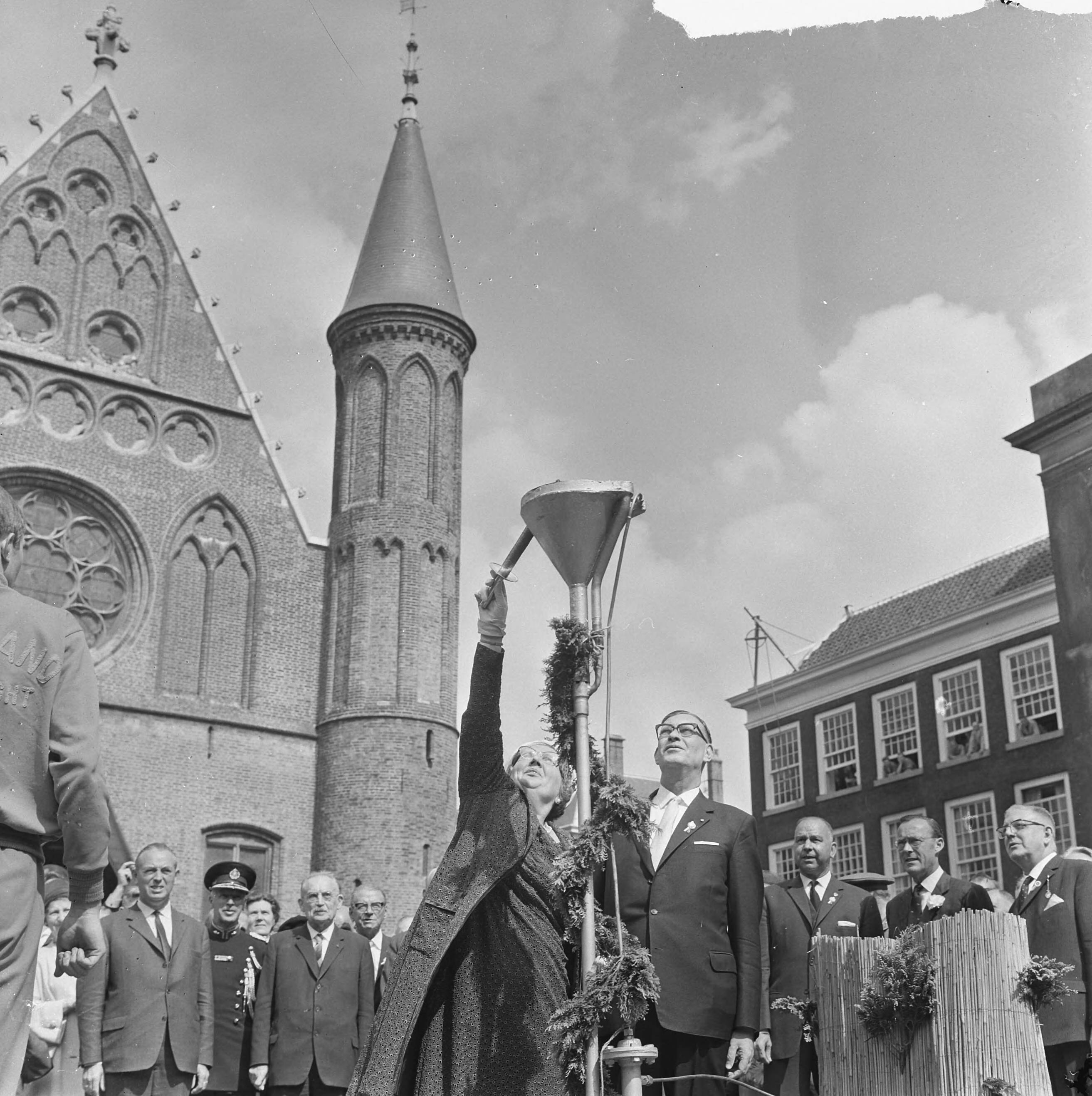 Vrijheidslustrum ex-politieke gevangenen te Den Haag — Koningin Juliana ontsteekt de vrijheidsvlam op het Binnenhof met een fakkel — Foto: Koch, Eric / Anefo. Licentie: Set B: Rechtenvrij / Publiek Domein. Bron: Nationaal Archief. http://hdl.handle.net/10648/aaaf5eb2-d0b4-102d-bcf8-003048976d84