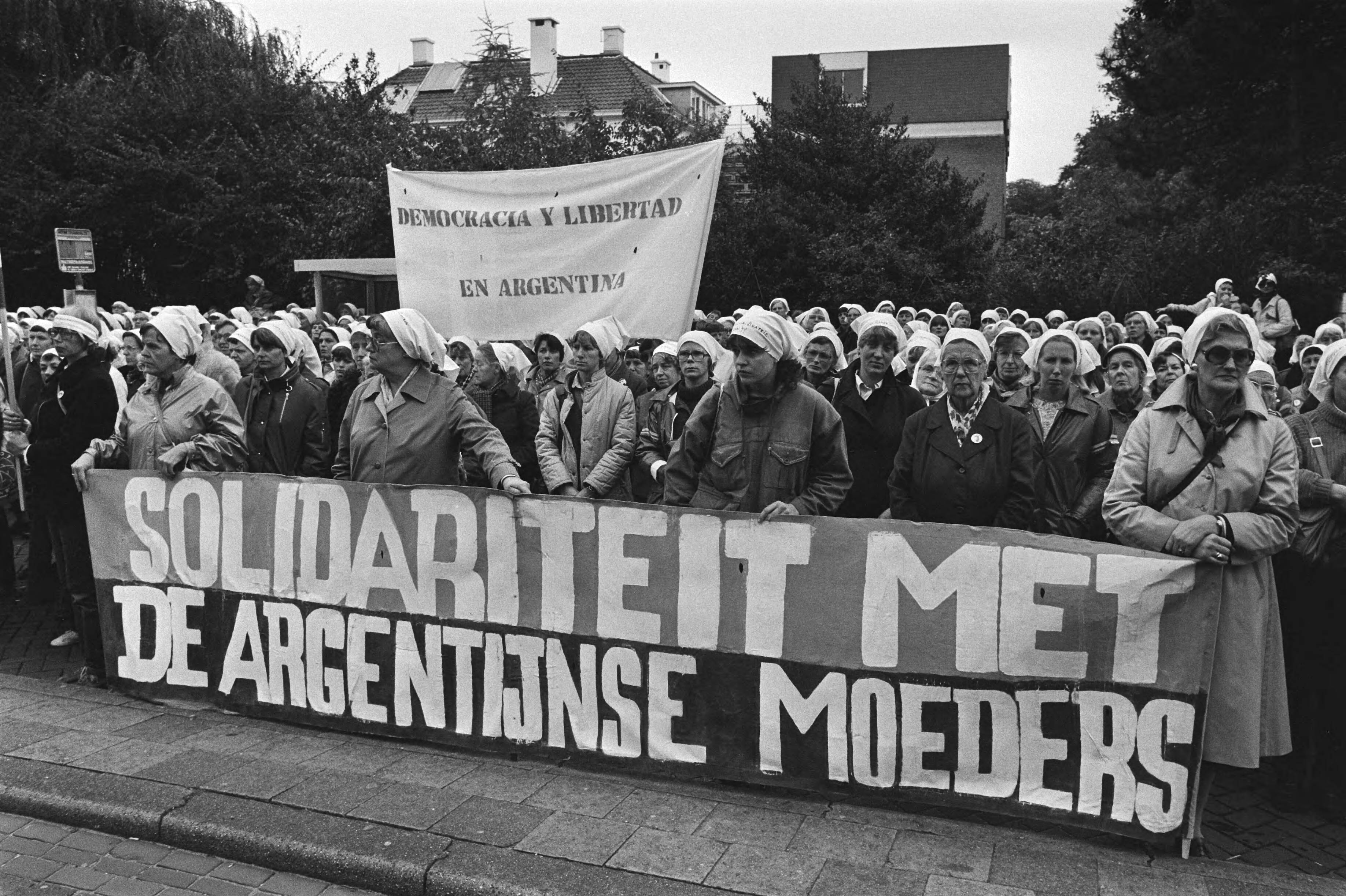 Demonstratie door vrouwen uit solidariteit met de "Dwaze Moeders" van Playa del Mayo in Den Haag — Kop van de stoet met spandoek — Foto: Bogaerts, Rob / Anefo. Licentie: Set B: Rechtenvrij / Publiek Domein. Bron: Nationaal Archief. http://hdl.handle.net/10648/ad065b7a-d0b4-102d-bcf8-003048976d84