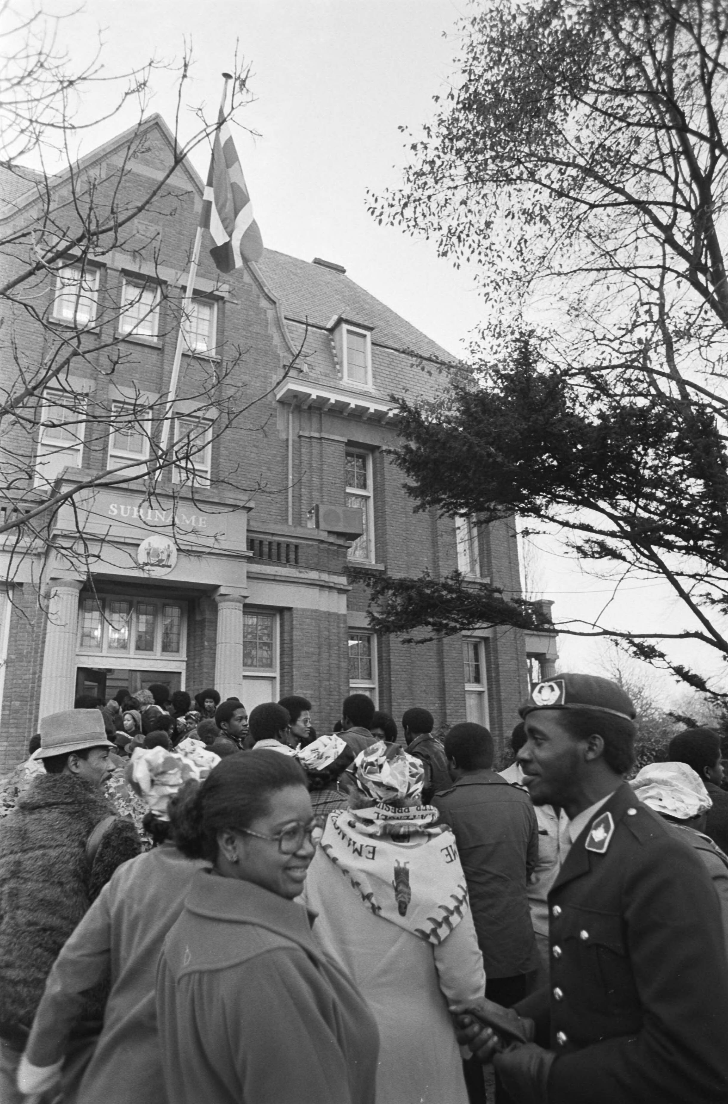 Fotocollectie Anefo — Surinaamse vlag gehesen bij Ambassade Suriname in Den Haag ; grote drukte voor de, nu, Surinaamse Ambassade — Foto: Mieremet, Rob / Anefo. Licentie: Set B: Rechtenvrij / Publiek Domein. Bron: Nationaal Archief. http://hdl.handle.net/10648/ac77cfe0-d0b4-102d-bcf8-003048976d84