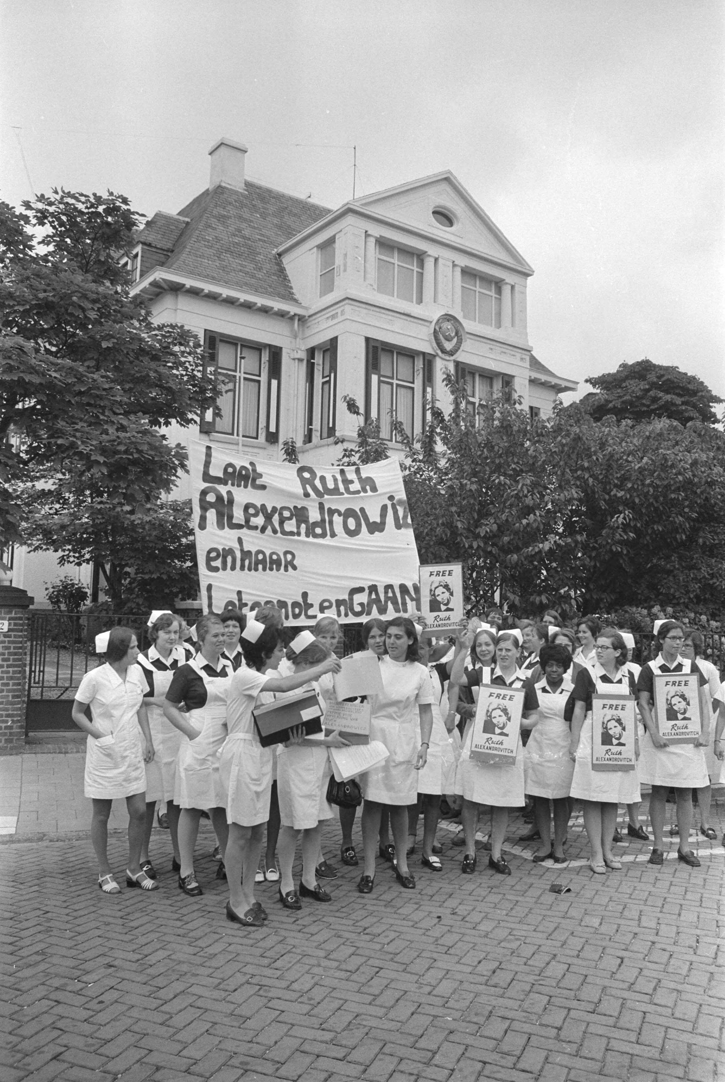 Verpleegsters demonstreren voor Russische ambassade in Den Haag tegen gevangenschap van Ruth Alexandrovitch — Verpleegsters met een spandoek voor de ambassade in Den Haag — Foto: Fotograaf Onbekend / Anefo. Licentie: Set B: Rechtenvrij / Publiek Domein. Bron: Nationaal Archief. http://hdl.handle.net/10648/abc2523c-d0b4-102d-bcf8-003048976d84