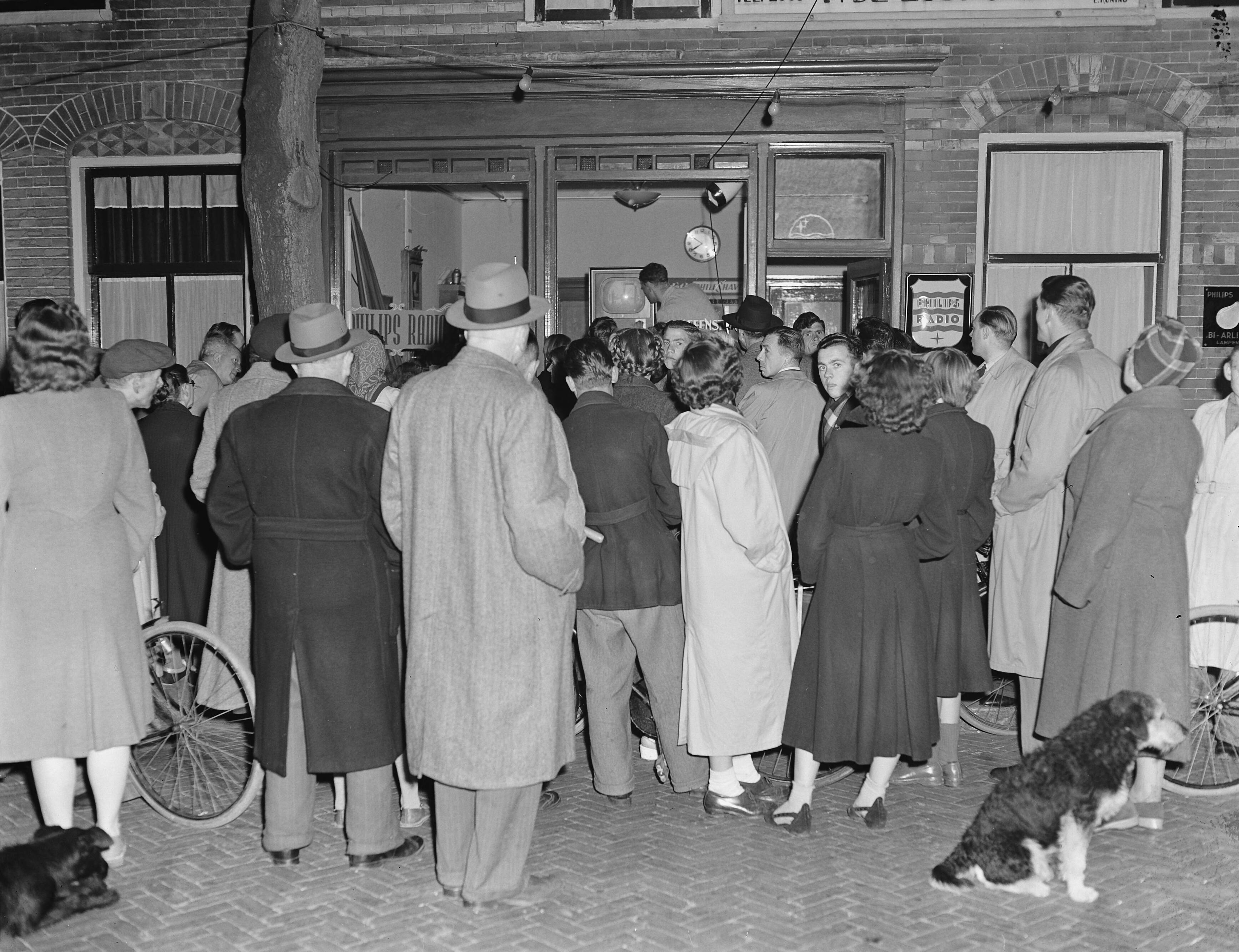 Fotocollectie Anefo — Publiek kijkt naar televisie in een etalage te Zandvoort — Foto: Pot, Harry / Anefo. Licentie: Set B: Rechtenvrij / Publiek Domein. Bron: Nationaal Archief. http://hdl.handle.net/10648/a8f07af2-d0b4-102d-bcf8-003048976d84