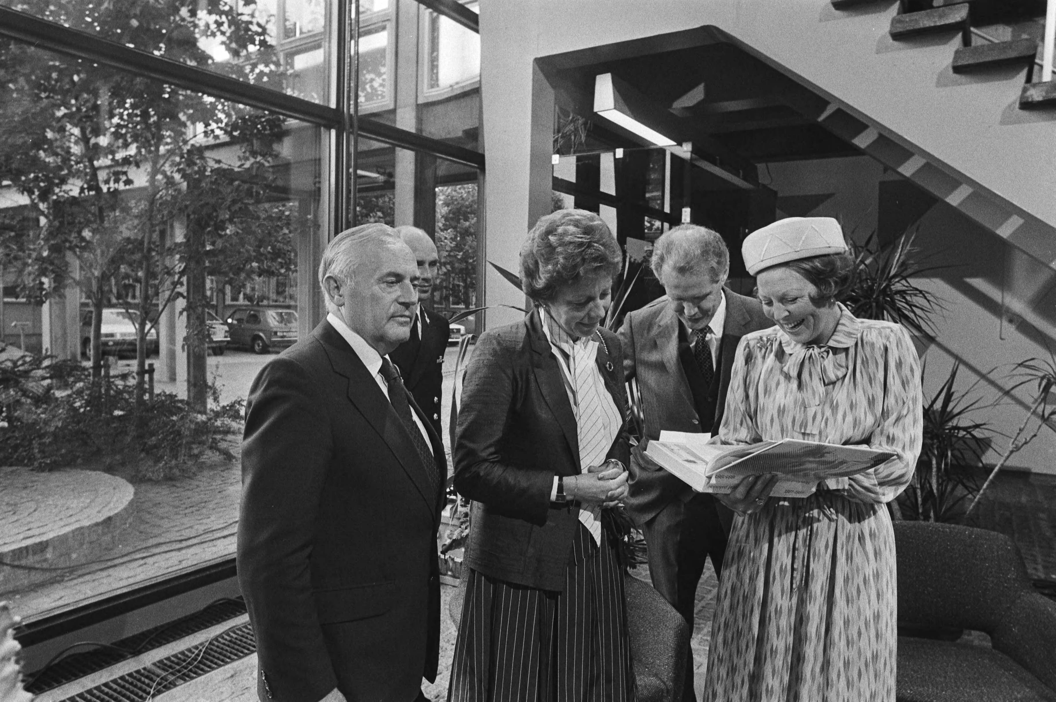 Bezoek van Koningin Beatrix aan de PTT in verband met het 100-jarig bestaan — Koningin Beatrix ontvangt in het Dr. Neherlaboratorium te Leidschendam (het ontwikkelingslaboratorium van de PTT) het jubileumboek "Honderd jaar telefonie" van v.l.n.r. de heer Ph. Leenman (directeur-generaal van de PTT), mevrouw Smit-Kroes (staatssecretaris van verkeer en waterstaat) en ir. A. Boesvelt (directeur dr. Neherlaboratorium) — Foto: Dijk, Hans van / Anefo. Licentie: Set B: Rechtenvrij / Publiek Domein. Bron: Nationaal Archief. http://hdl.handle.net/10648/ad029efe-d0b4-102d-bcf8-003048976d84