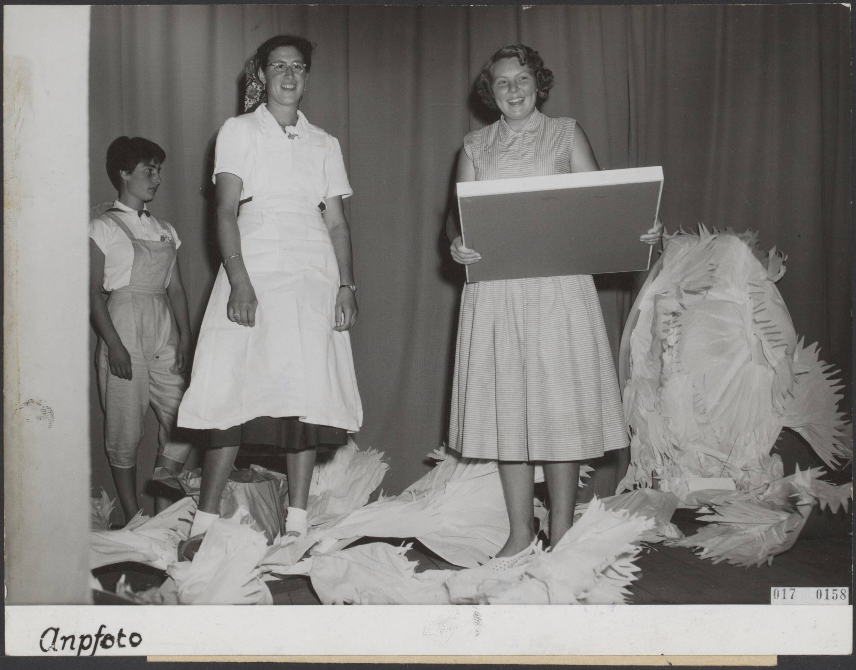 Fotocollectie Elsevier Binnenland — De beste amateur toneelspelers uit Limburg, die gedurende de Anjer toneelcompetitie voor het Provinciaal Anjercomité opgetreden zijn, en daarbij een bedrag van fl. 80.000,- ophaalden, een voorstelling gegeven voor de koninklijke familie in de Orangerie te Soestdijk. De prinsessen Beatrix en Irene openden ieder een anjer op toneel en kwamen tot de ontdekking dat zich daarin meisjes bevonden, waarmede de prinsessen gedurende hun vakantieverblijk in Limburg dagelijks melkten — Foto: ANP / RVD of rechtenvrij. Licentie: Set B: Rechtenvrij / Publiek Domein. Bron: Nationaal Archief. http://hdl.handle.net/10648/adbceee4-d0b4-102d-bcf8-003048976d84