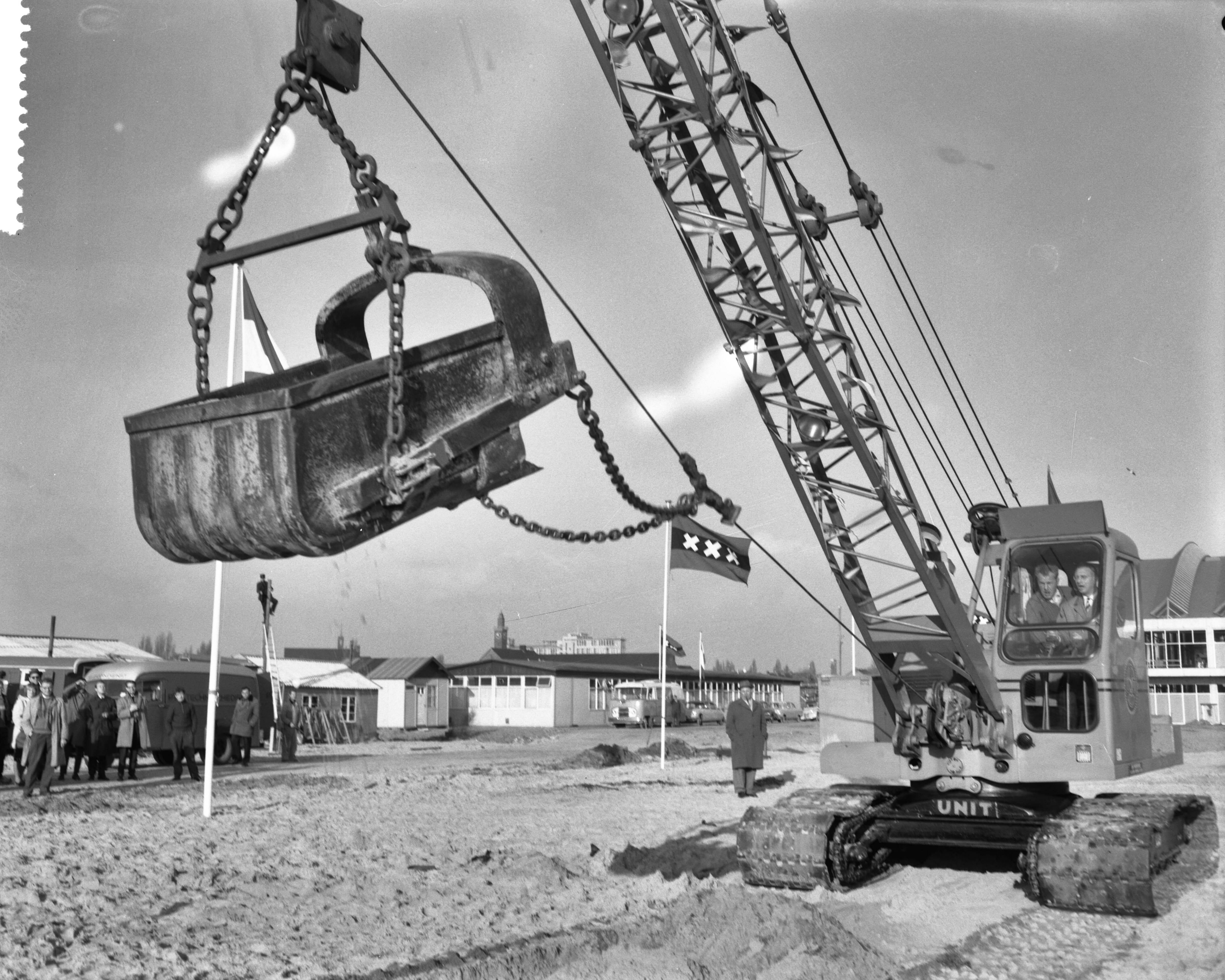 Fotocollectie Anefo — Aanvang werkzaamheden voor het RAI-congresgebouw op het Europaplein te Amsterdam. Wethouder Van 't Hull verplaatst met dragline de eerste kubieke meter zand — Foto: Bilsen, Joop van / Anefo. Licentie: Set B: Rechtenvrij / Publiek Domein. Bron: Nationaal Archief. http://hdl.handle.net/10648/a9c0f286-d0b4-102d-bcf8-003048976d84