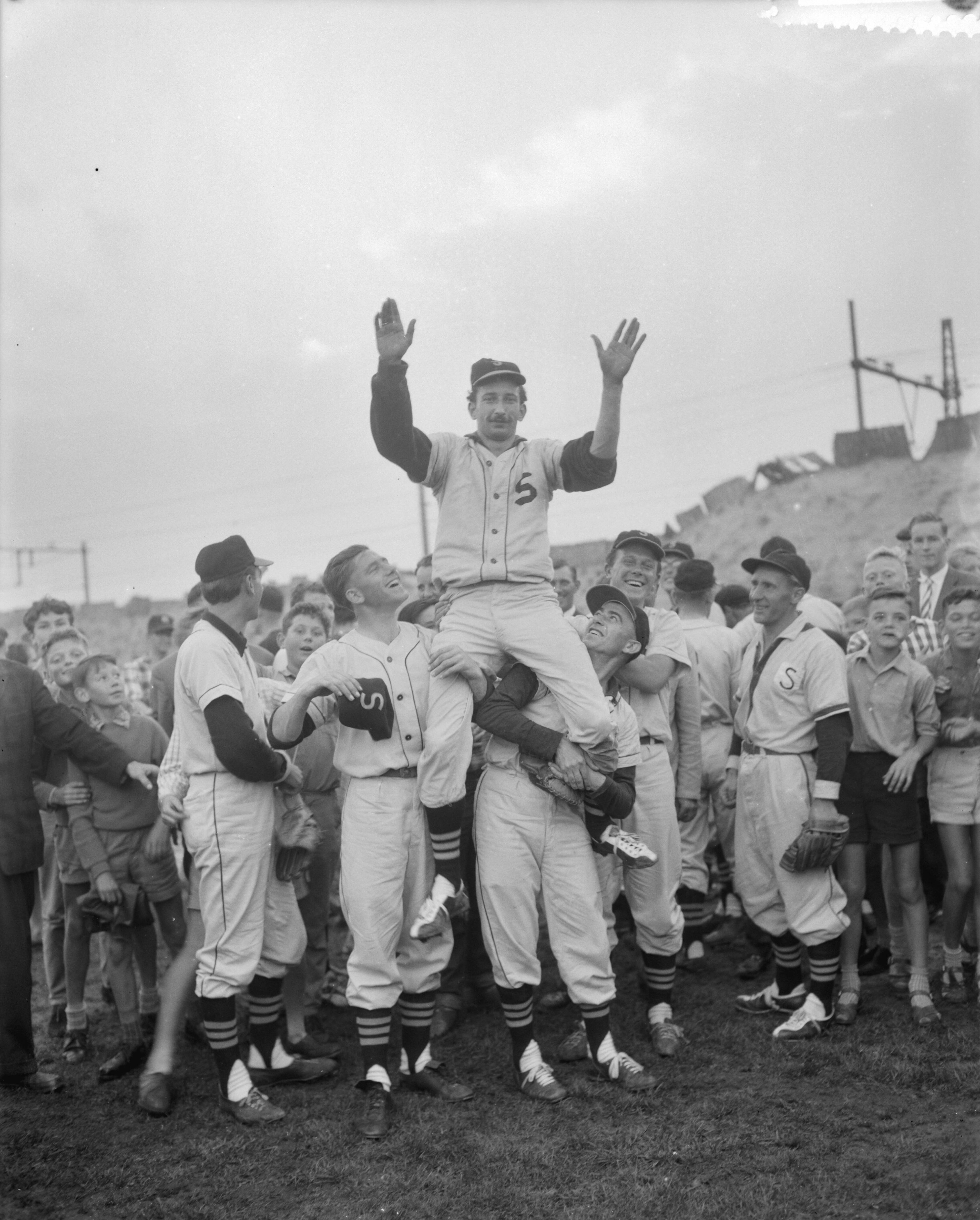 Fotocollectie Anefo — Honkbal. Schoten tegen Sparta 3-2. Simon Heemskerk, maker van het winnende punt, op de schouders van de Schotenspelers — Foto: Bilsen, Joop van / Anefo. Licentie: Set B: Rechtenvrij / Publiek Domein. Bron: Nationaal Archief. http://hdl.handle.net/10648/a9b7b522-d0b4-102d-bcf8-003048976d84