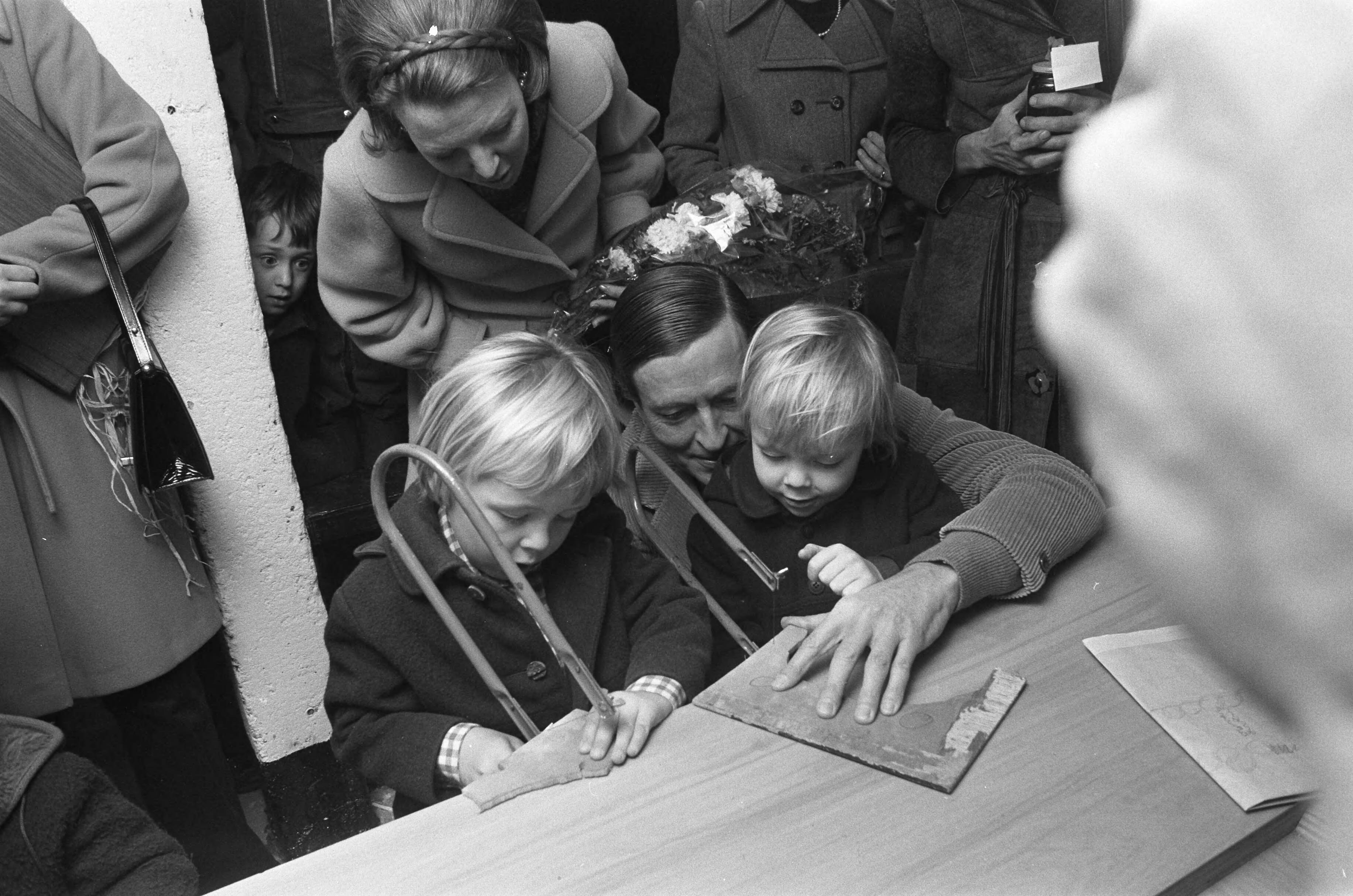 Prinses Beatrix en Prins Claus met hun kinderen bij de opening van kinderboerderij "De Vrije Teugel" in Soest — Prins Claus helpt Johan Friso (rechts) en Constantijn bij het figuurzagen, op de achtergrond prinses Beatrix — Foto: Fotograaf Onbekend / Anefo. Licentie: Set B: Rechtenvrij / Publiek Domein. Bron: Nationaal Archief. http://hdl.handle.net/10648/ac3cab72-d0b4-102d-bcf8-003048976d84