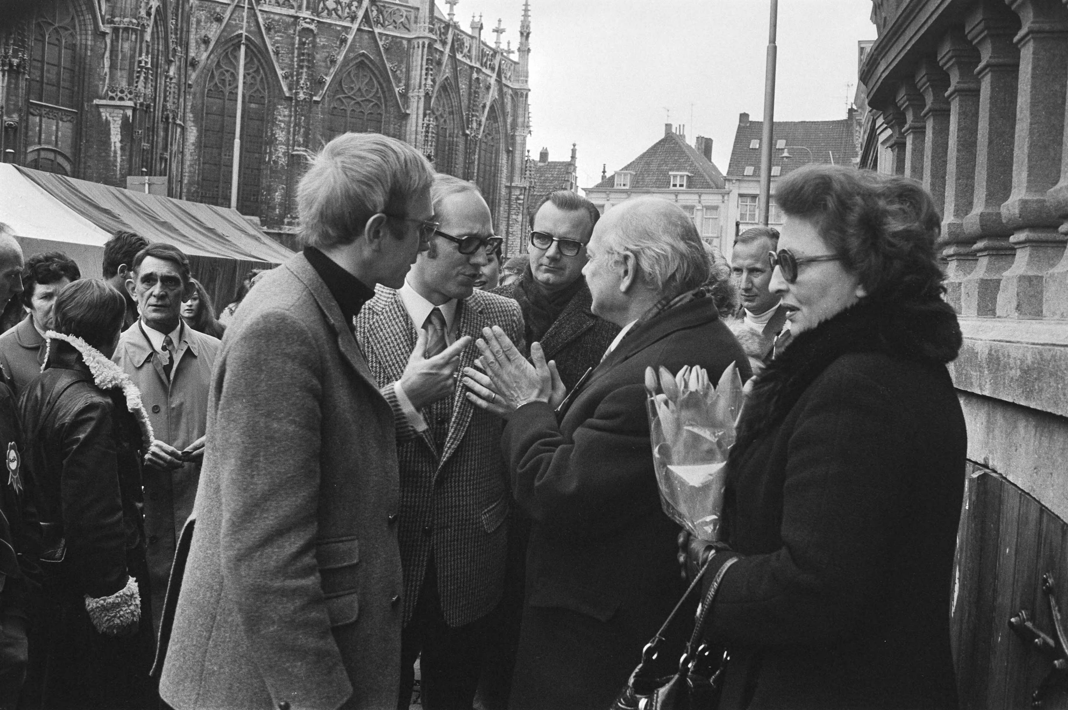 Joop den Uyl in Breda met een karavaan op verkiezingstournee voor de PvdA — Den Uyl in gesprek met omstanders, rechts Liesbeth den Uyl-Van Vessem — Foto: Fotograaf Onbekend / Anefo. Licentie: Set B: Rechtenvrij / Publiek Domein. Bron: Nationaal Archief. http://hdl.handle.net/10648/abb8df86-d0b4-102d-bcf8-003048976d84