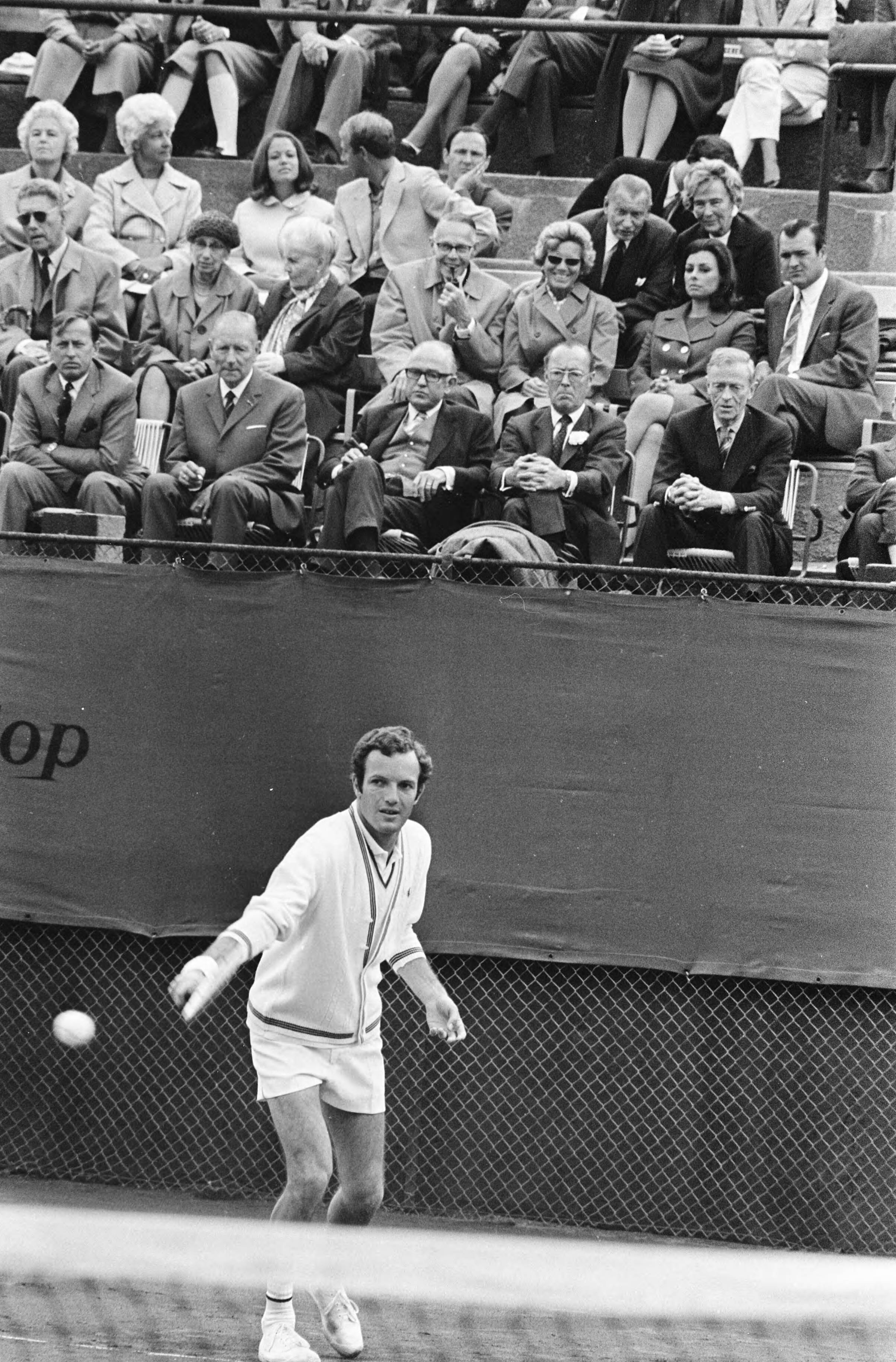 Tennistoernooi op METS-banen te Scheveningen — Tom Okker in aktie; Prins Bernhard op tribune (onderste rij, tweede van rechts) — Foto: Fotograaf Onbekend / Anefo. Licentie: Set B: Rechtenvrij / Publiek Domein. Bron: Nationaal Archief. http://hdl.handle.net/10648/ab9b727a-d0b4-102d-bcf8-003048976d84