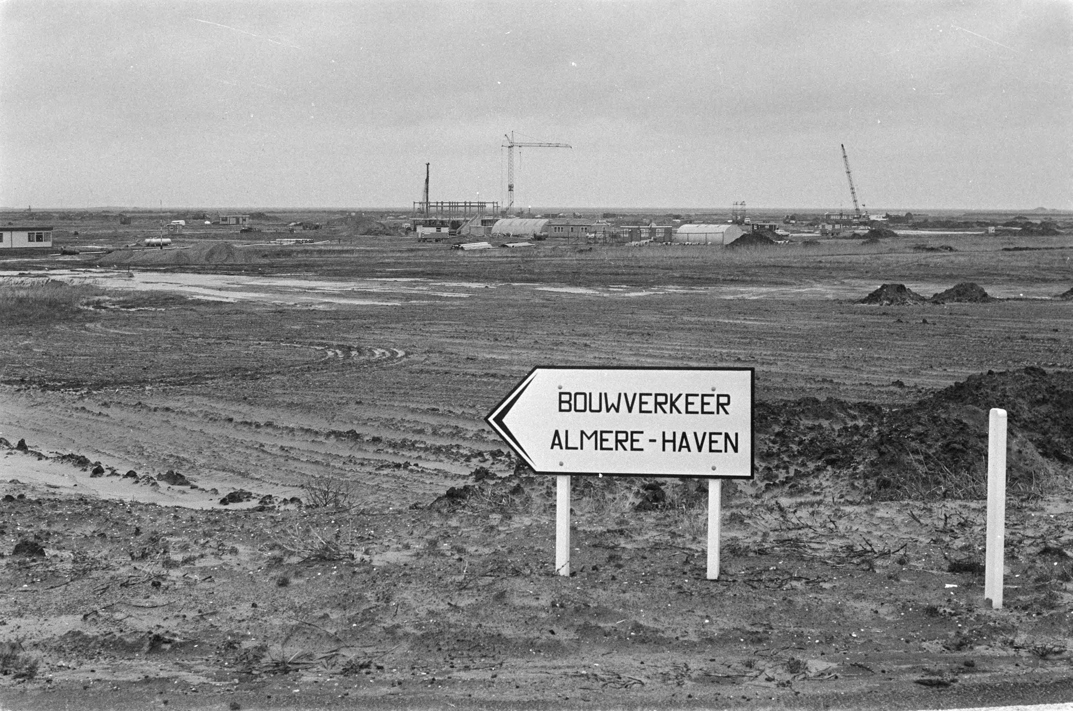 Fotocollectie Anefo — Bouw Almere in Zuid-Flevopolder; overzicht werkzaamheden in polder (met bord "Almere haven" ) — Foto: Mieremet, Rob / Anefo. Licentie: Set B: Rechtenvrij / Publiek Domein. Bron: Nationaal Archief. http://hdl.handle.net/10648/ac7a524c-d0b4-102d-bcf8-003048976d84