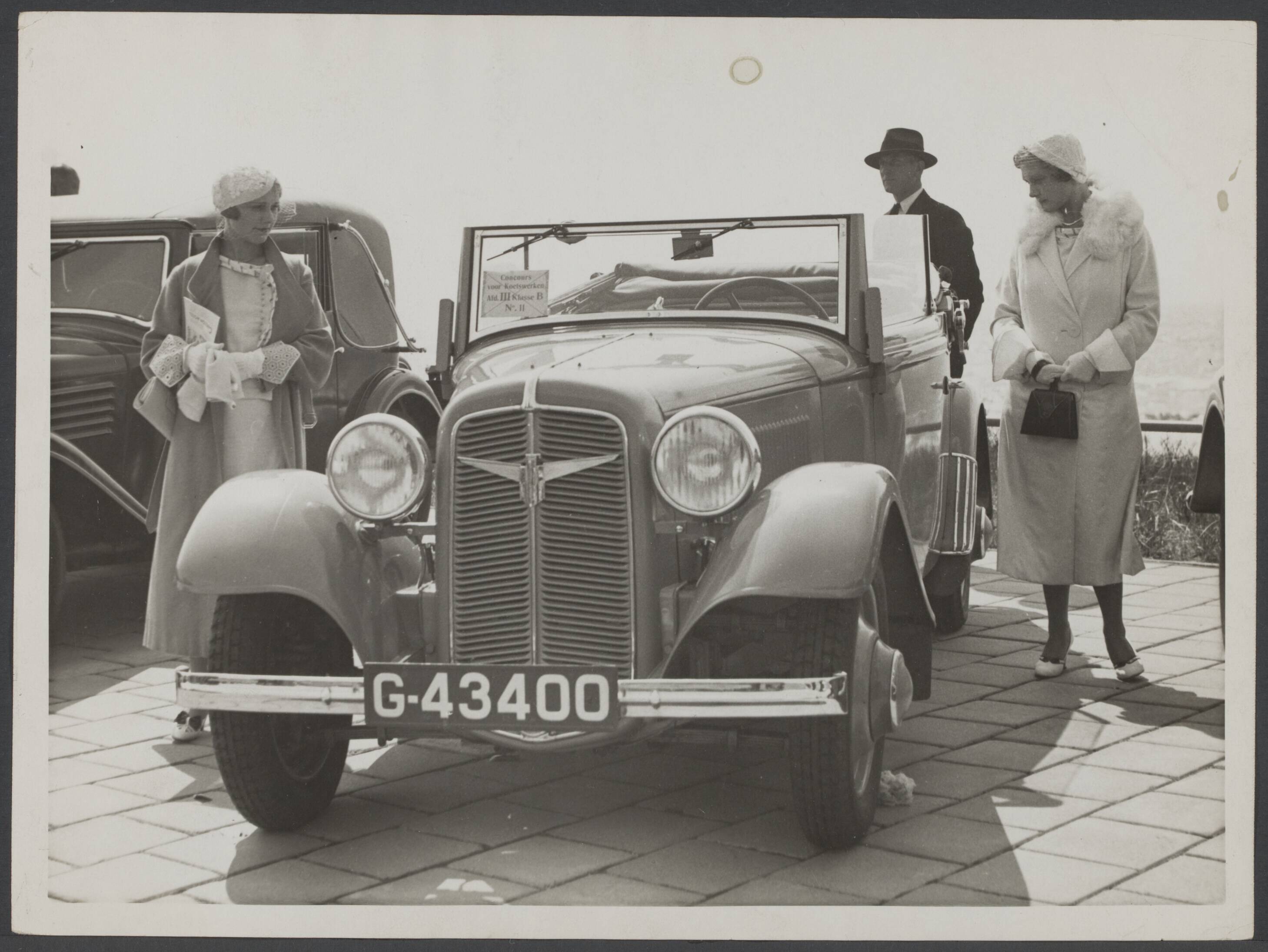 Autotentoonstellingen tot 1965, concours d'elegance, mode en auto — Concours van automobielen te Zandvoort, georganiseerd door de K.N.A.C.. Fraaie sportwagentjes trekken de aandacht van nog fraaiere meisjes — Foto: N.V. Polygoon. Licentie: Set B: Rechtenvrij / Publiek Domein. Bron: Nationaal Archief. http://hdl.handle.net/10648/56c5477f-3eef-31d5-8fdb-896d018ec109