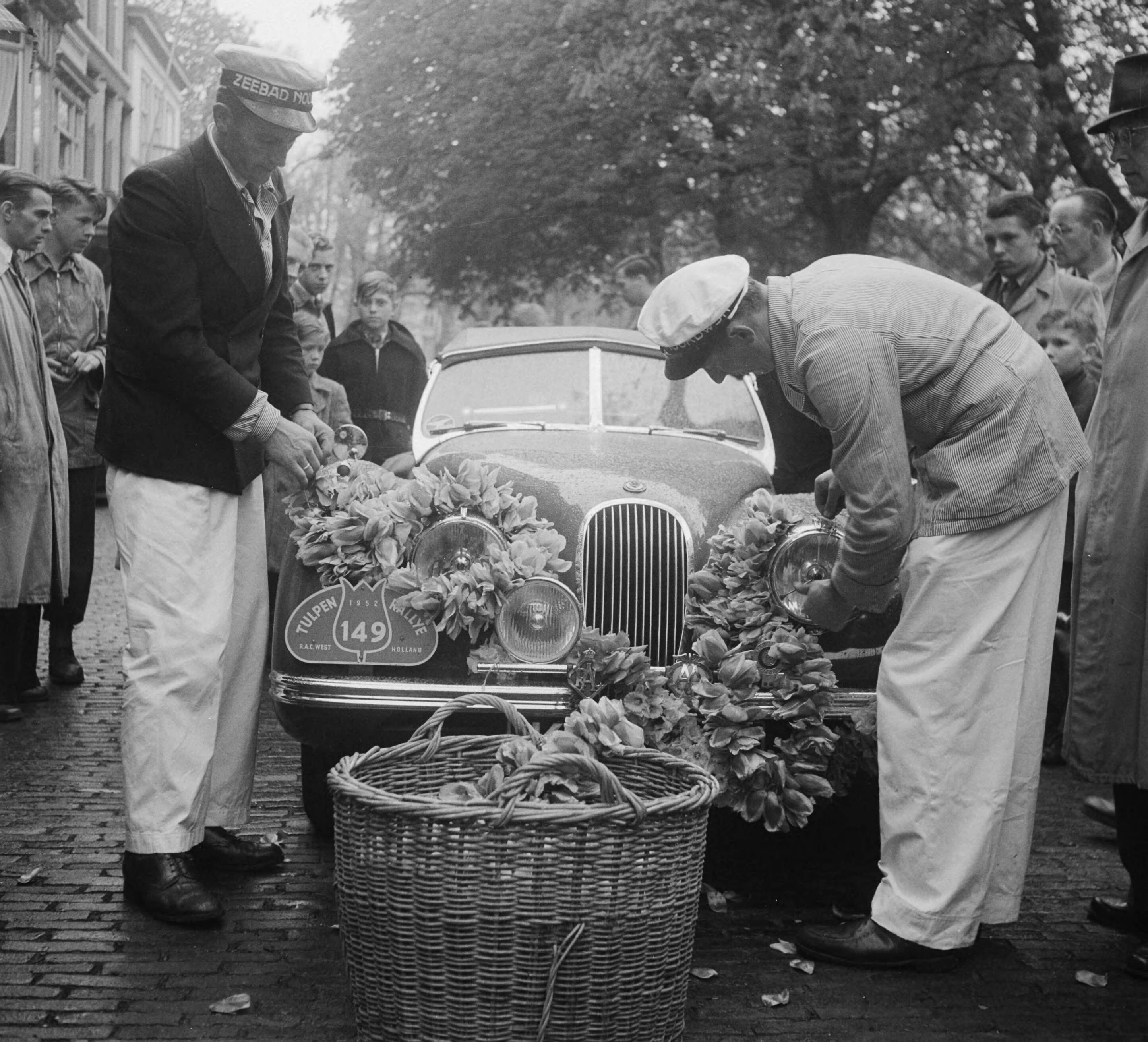 Tulpenrally 1952 — Tulpenralley. Start Den Haag. Deelnemende auto wordt met bloemenslingers gedecoreerd — Foto: Pot, Harry / Anefo. Licentie: Set B: Rechtenvrij / Publiek Domein. Bron: Nationaal Archief. http://hdl.handle.net/10648/a8f8859e-d0b4-102d-bcf8-003048976d84
