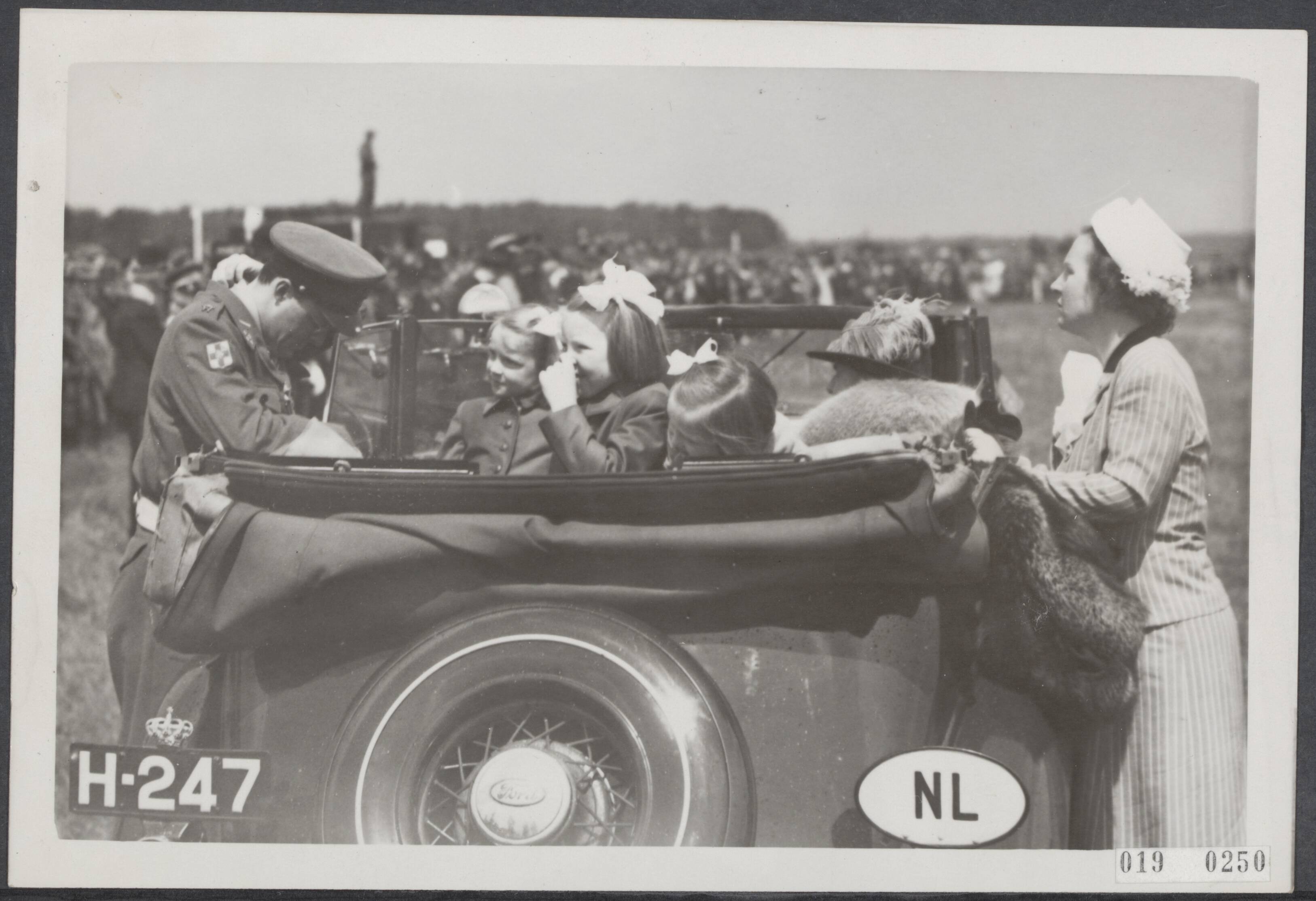 Fotocollectie Elsevier Binnenland — Op het vliegveld Soesterberg heeft koningin Wilhelmina de Militaire Willemsorde uitgereikt aan een aantal mannen die zich tijdens de Meidagen van 1940 en in het verzet tegen de Duitsers hebben onderscheiden. Prins Bernhard toont de onderscheiding aan de prinsesjes — Foto: ANP / RVD of rechtenvrij. Licentie: Set B: Rechtenvrij / Publiek Domein. Bron: Nationaal Archief. http://hdl.handle.net/10648/adc5f228-d0b4-102d-bcf8-003048976d84