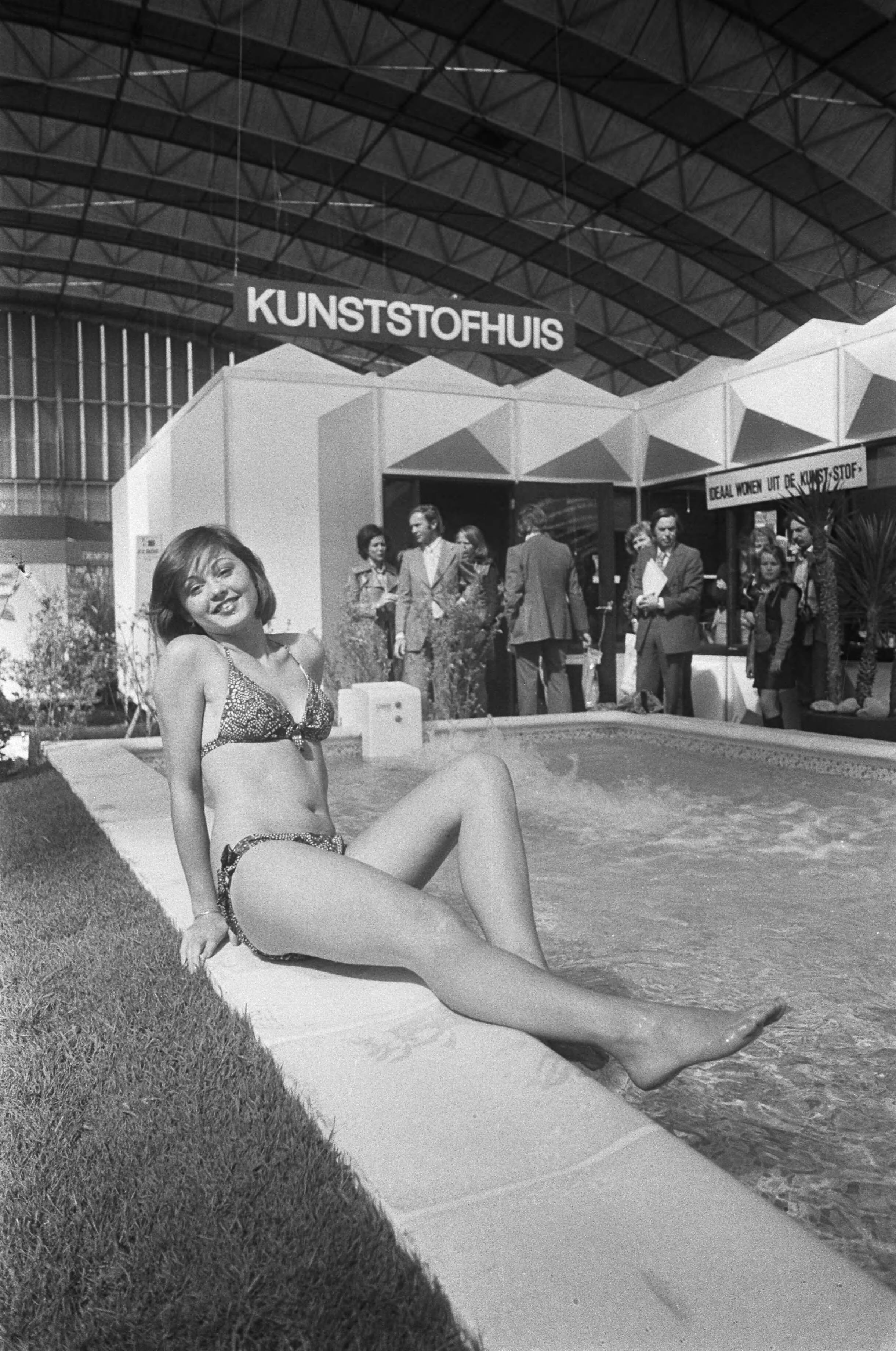 Fotocollectie Anefo — 29e Internationale Huishoudbeurs in de RAI te Amsterdam. Model poseert bij zwembad — Foto: Peters, Hans / Anefo. Licentie: Set B: Rechtenvrij / Publiek Domein. Bron: Nationaal Archief. http://hdl.handle.net/10648/ac48a378-d0b4-102d-bcf8-003048976d84