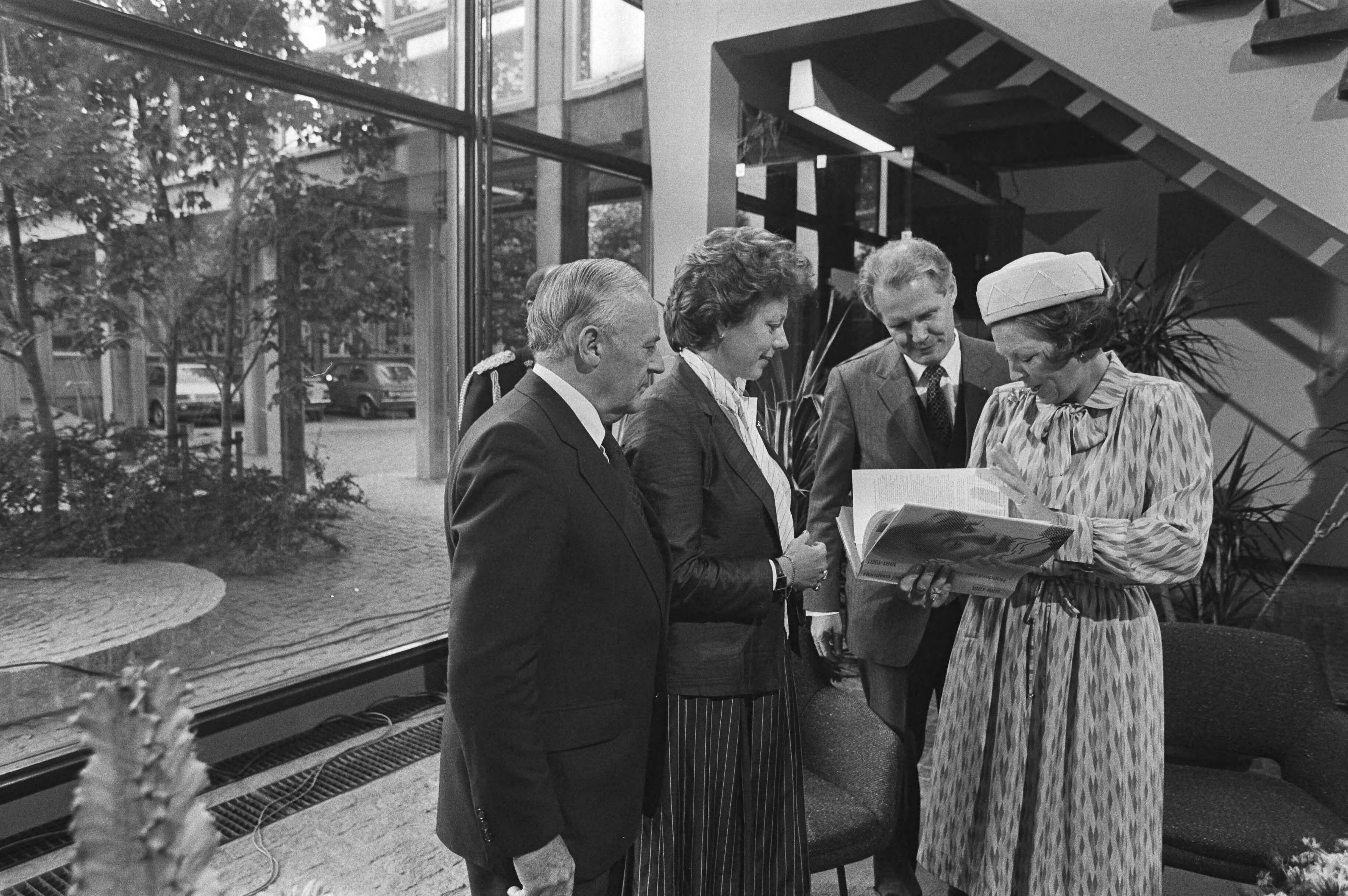 Bezoek van Koningin Beatrix aan de PTT in verband met het 100-jarig bestaan — Koningin Beatrix ontvangt in het Dr. Neherlaboratorium te Leidschendam (het ontwikkelingslaboratorium van de PTT) het jubileumboek "Honderd jaar telefonie" van v.l.n.r. de heer Ph. Leenman (directeur-generaal van de PTT), mevrouw Smit-Kroes (staatssecretaris van verkeer en waterstaat) en ir. A. Boesvelt (directeur dr. Neherlaboratorium) — Foto: Dijk, Hans van / Anefo. Licentie: Set B: Rechtenvrij / Publiek Domein. Bron: Nationaal Archief. http://hdl.handle.net/10648/ad029fd0-d0b4-102d-bcf8-003048976d84