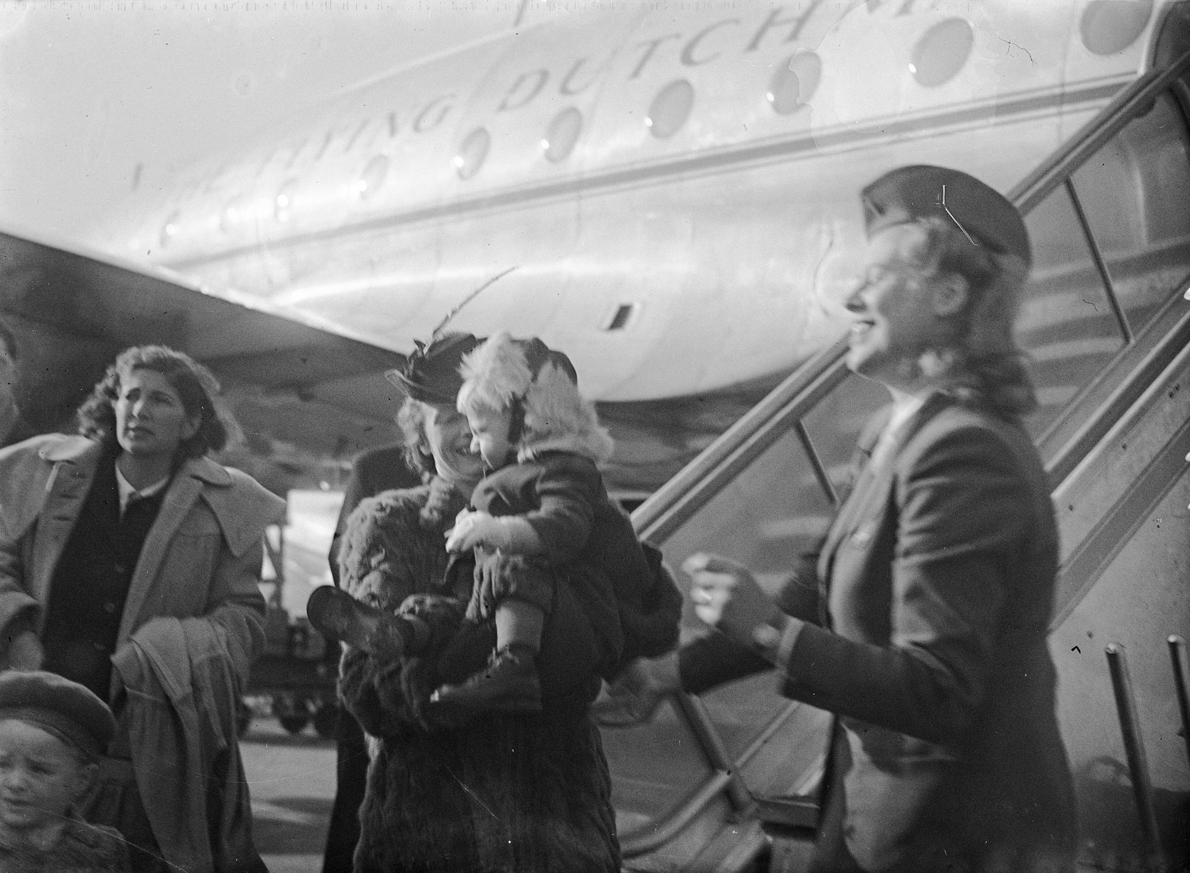Fotocollectie Anefo — Amsterdamse baby Herman van Eck terug op Schiphol. In de armen van zijn moeder — Foto: Sagers, Harry / Anefo. Licentie: Set B: Rechtenvrij / Publiek Domein. Bron: Nationaal Archief. http://hdl.handle.net/10648/a8aee3ee-d0b4-102d-bcf8-003048976d84