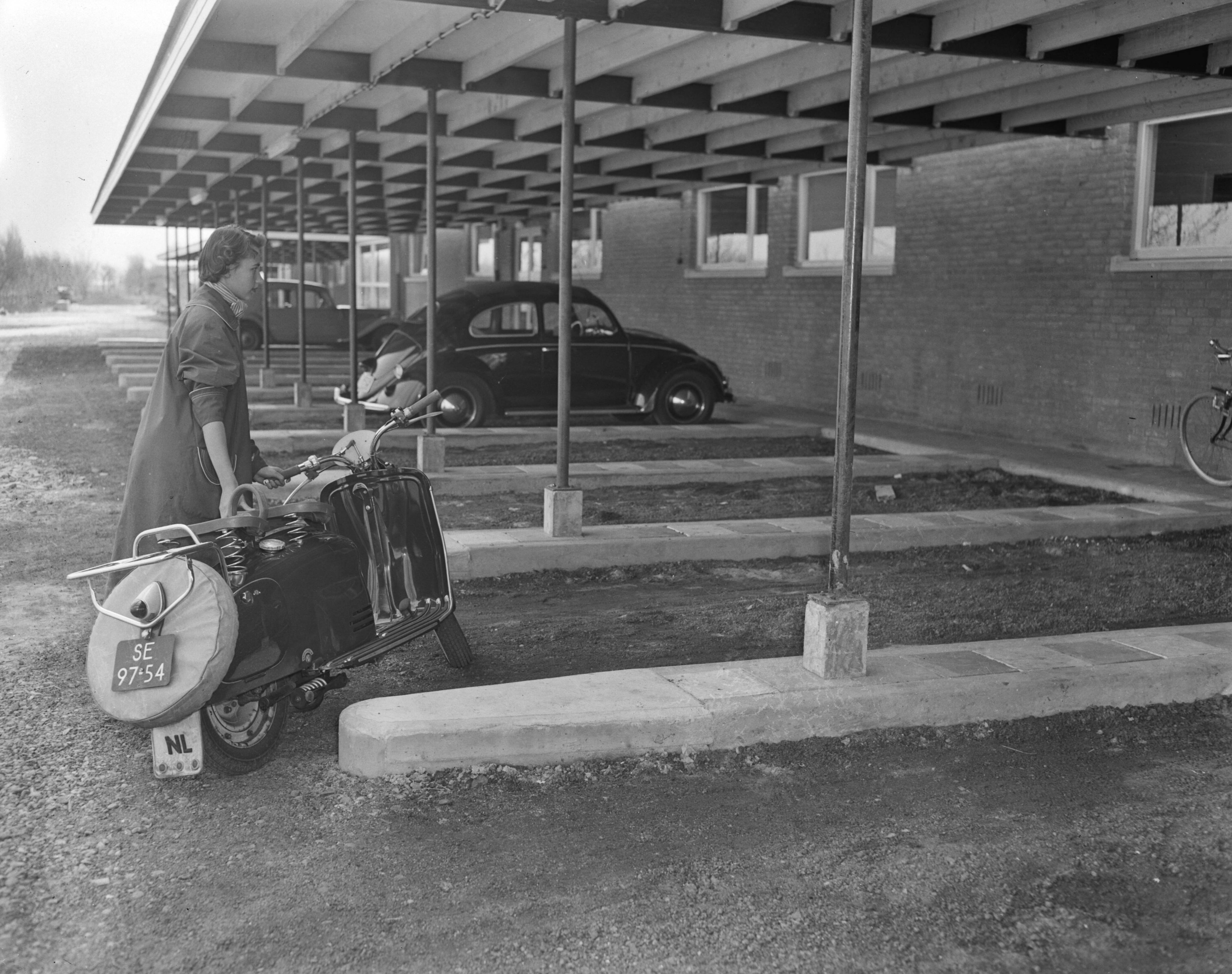 Motel aan de Rijksweg te Voorburg — Motel "Hoornwijck" aan de Rijksweg te Voorburg. Overdekte parkeerplaatsen. Vrouw met motorscooter — Foto: Pot, Harry / Anefo. Licentie: Set B: Rechtenvrij / Publiek Domein. Bron: Nationaal Archief. http://hdl.handle.net/10648/a9472442-d0b4-102d-bcf8-003048976d84
