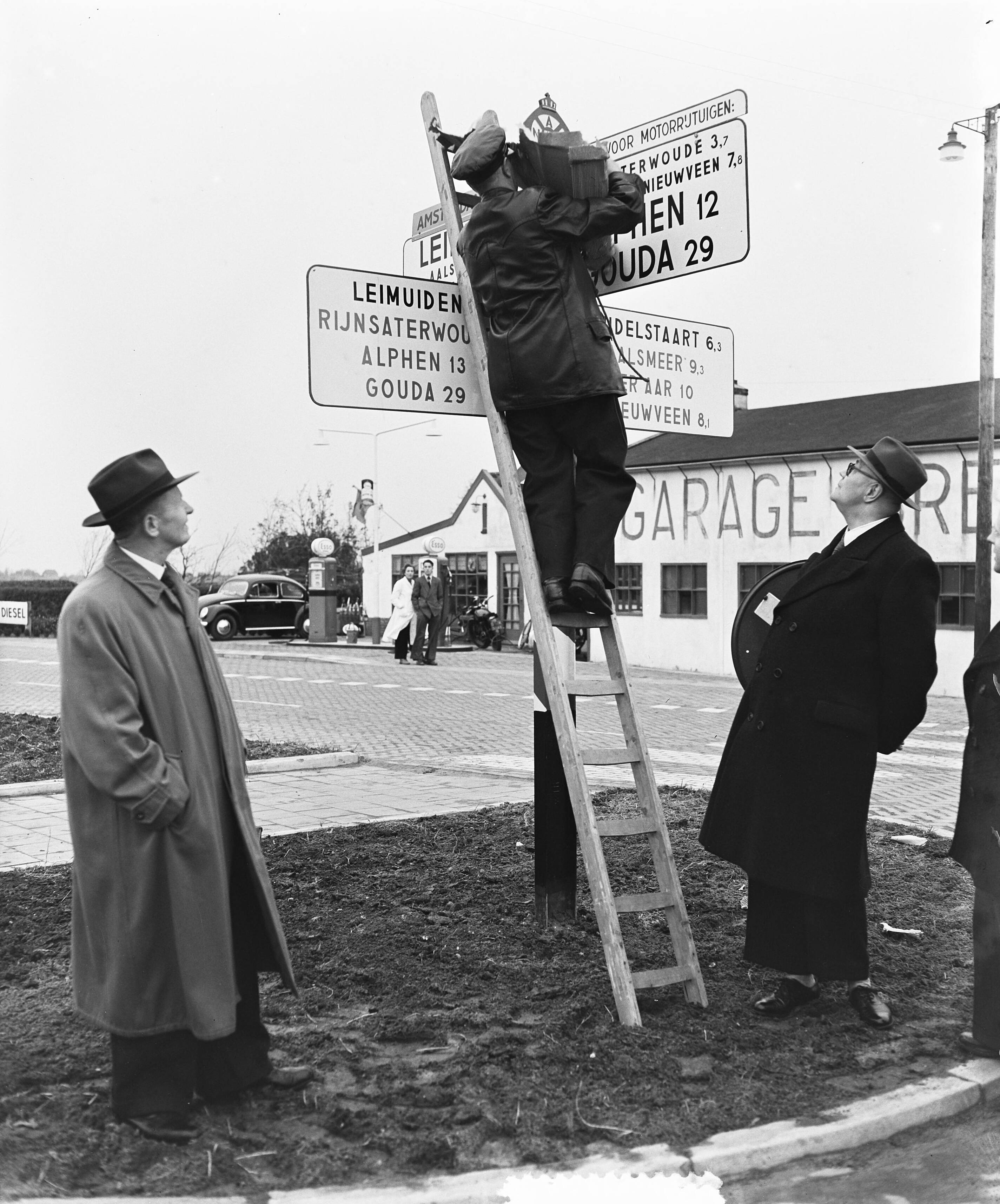 Fotocollectie Anefo — Opheffing tol te Leimuiden. Een ANWB wegweijzer wordt aangepast aan de nieuwe situatie — Foto: Rossem, Wim van / Anefo. Licentie: Set B: Rechtenvrij / Publiek Domein. Bron: Nationaal Archief. http://hdl.handle.net/10648/a91756f4-d0b4-102d-bcf8-003048976d84