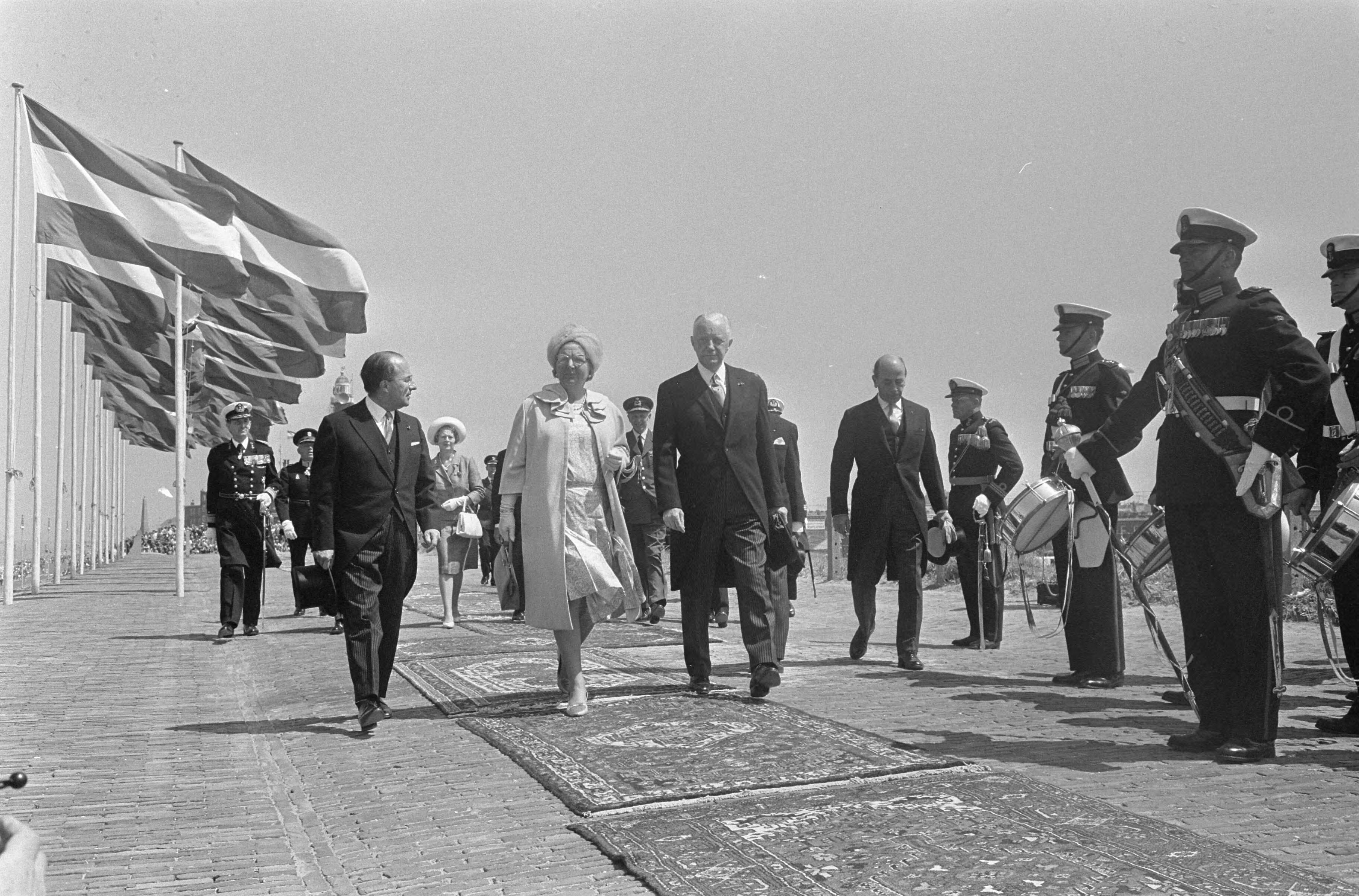 Koningin Juliana onthult het Marinemonument te Scheveningen — Koningin Juliana in gezelschap — Foto: Koch, Eric / Anefo. Licentie: Set B: Rechtenvrij / Publiek Domein. Bron: Nationaal Archief. http://hdl.handle.net/10648/aaee7728-d0b4-102d-bcf8-003048976d84