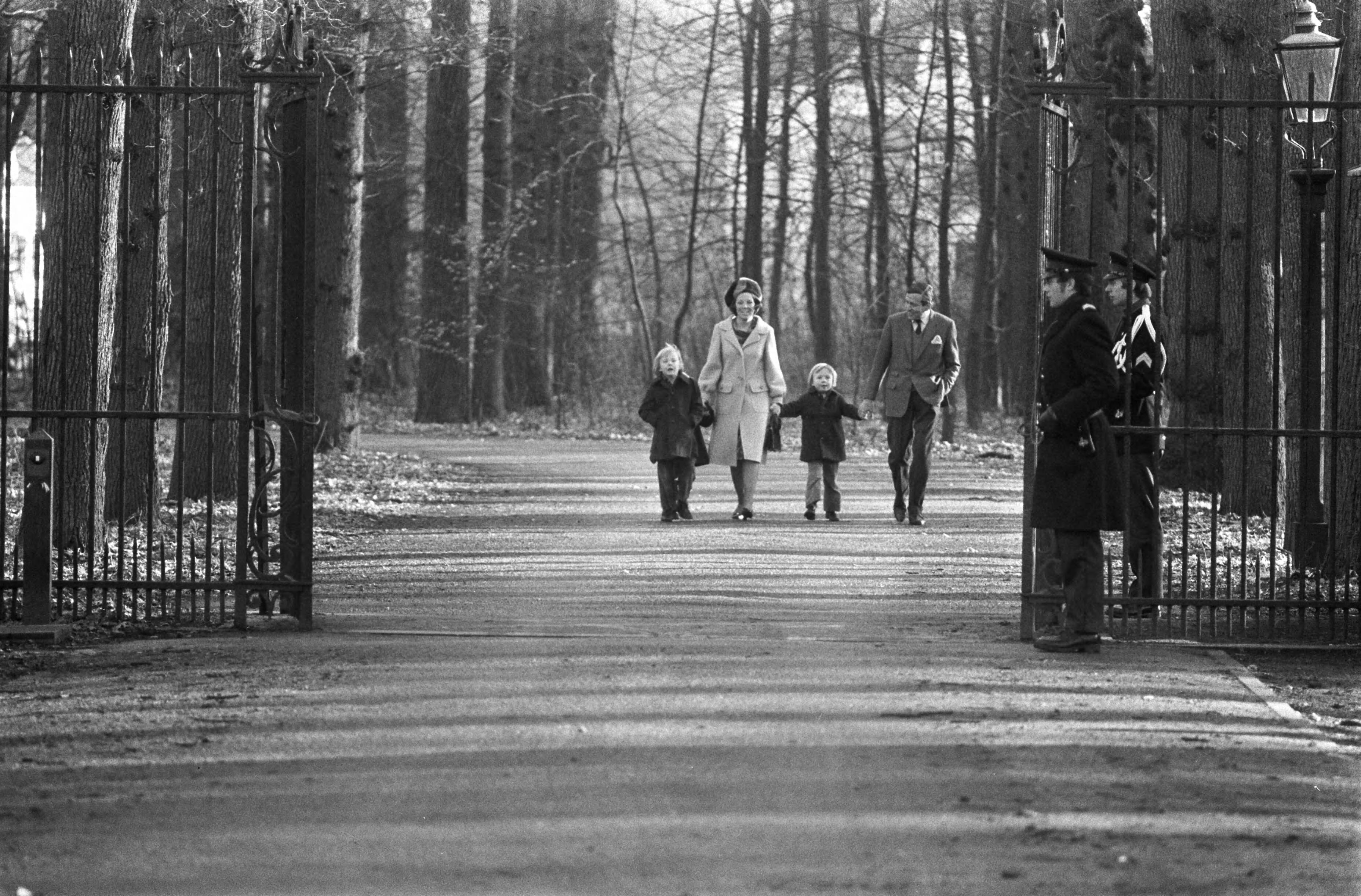 Prinses Beatrix opent het dorpshuis Lage Vuursche — Prinses Beatrix en Prins Claus lopen hand in hand met Willem-Alexander (l) en Constantijn over de toegangslaan, op de voorgrond twee leden van de marechaussee — Foto: Fotograaf Onbekend / Anefo. Licentie: Set B: Rechtenvrij / Publiek Domein. Bron: Nationaal Archief. http://hdl.handle.net/10648/ac427bba-d0b4-102d-bcf8-003048976d84