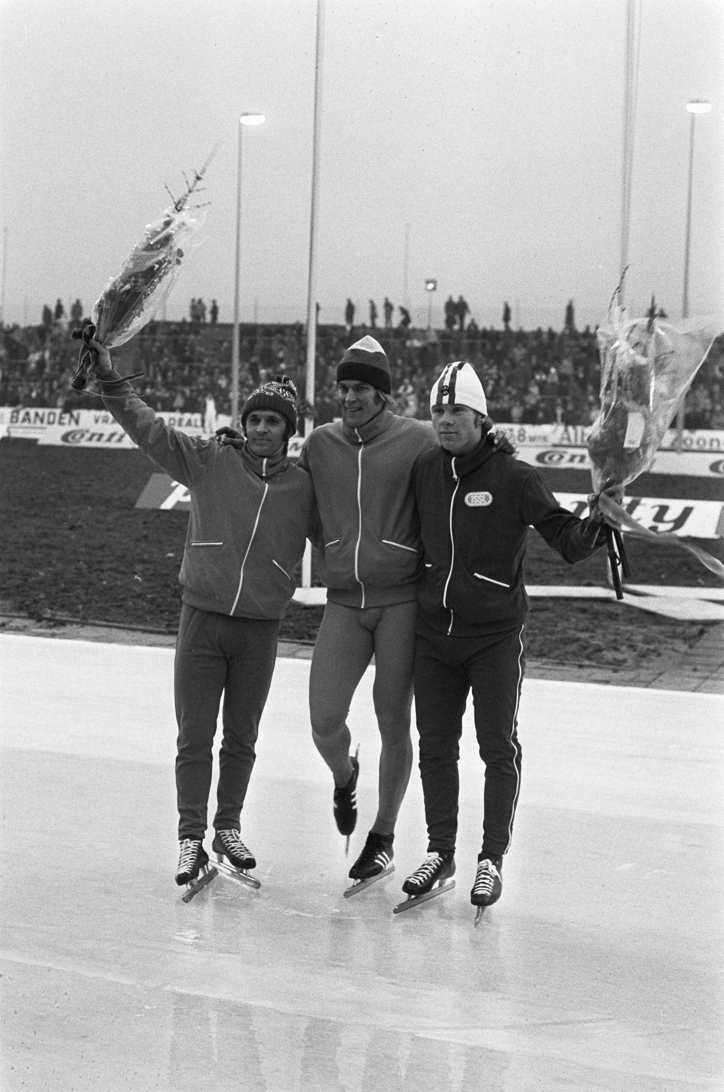 Fotocollectie Anefo — Schaatswedstrijden voor eerste ISSL World Cup voor prof op De Uithof in Den Haag , v.l.n.r. Bols, Schenk, Olsen met bloemen, huldiging 5000 meter / — Foto: Verhoeff, Bert / Anefo. Licentie: Set B: Rechtenvrij / Publiek Domein. Bron: Nationaal Archief. http://hdl.handle.net/10648/ac21c4e2-d0b4-102d-bcf8-003048976d84