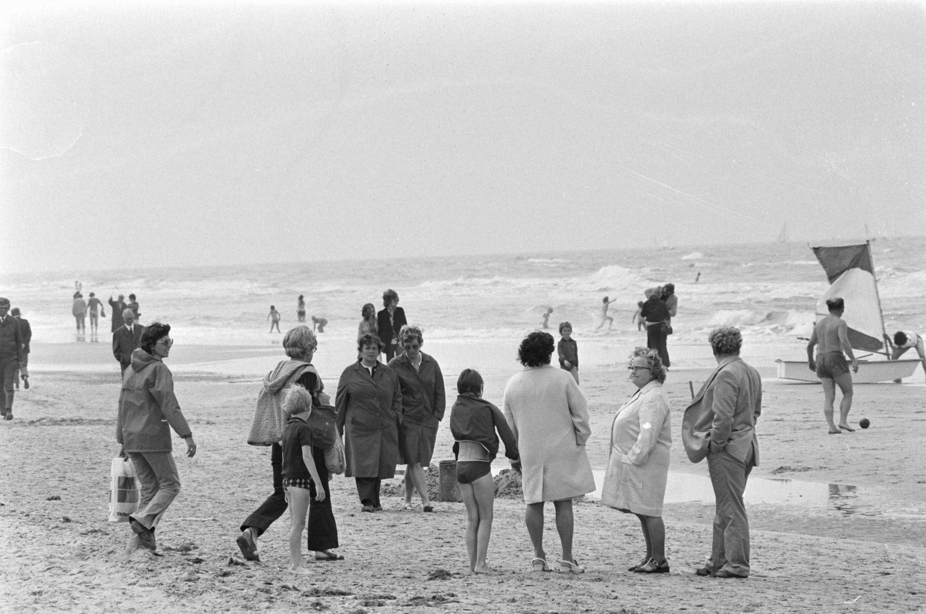 Fotocollectie Anefo — Slecht weer op Zandvoort; dik aangeklede mensen op strand — Foto: Mieremet, Rob / Anefo. Licentie: Set B: Rechtenvrij / Publiek Domein. Bron: Nationaal Archief. http://hdl.handle.net/10648/ac503e76-d0b4-102d-bcf8-003048976d84
