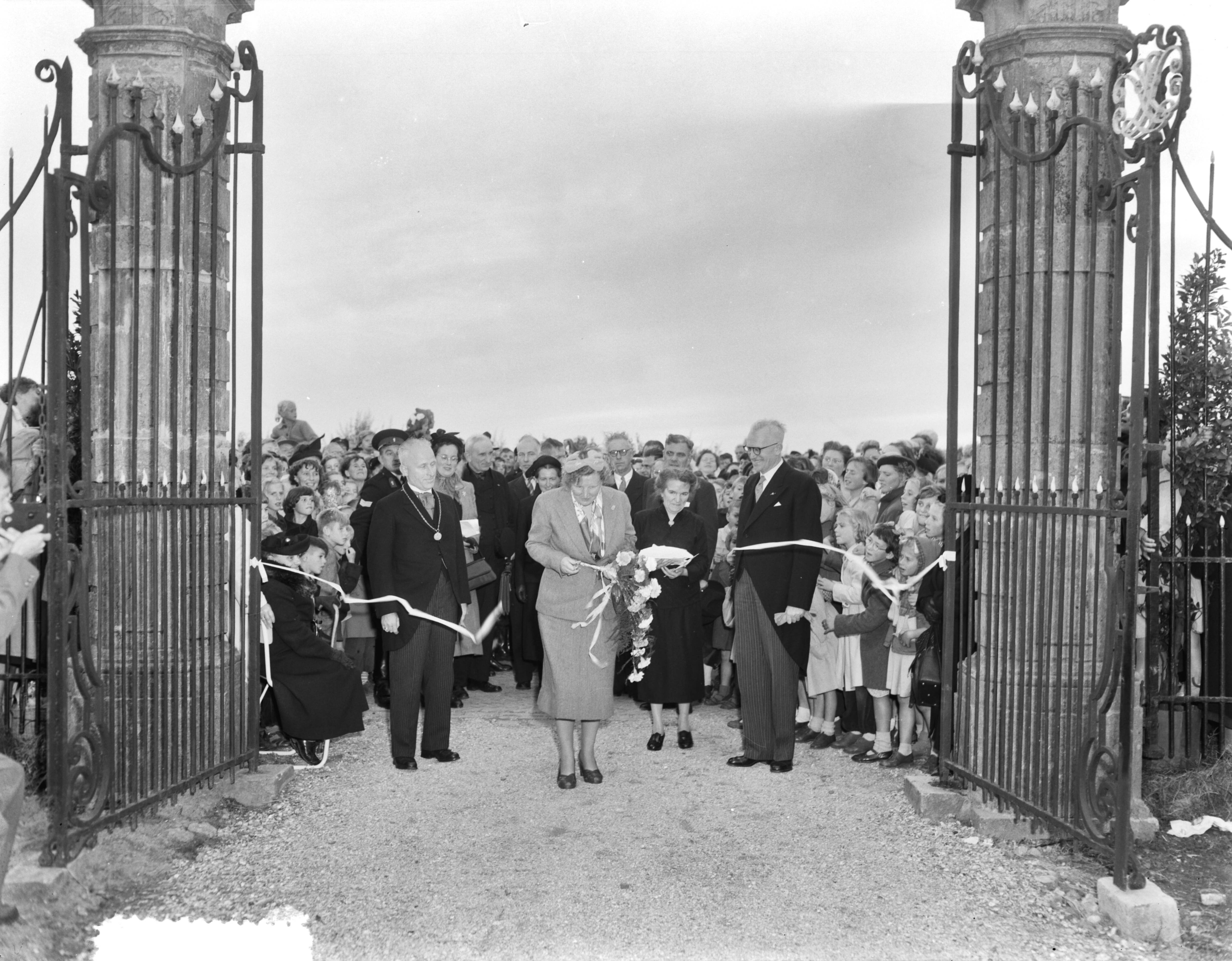 Koningin Juliana verricht de opening van de uitbreiding van het verpleeghuis Der Boede — Koningin Juliana op Duiveland, Het verpleeghuis Der Boede in Koudekerke, Koningin Juliana knipt een lint door — Foto: Duinen, G.W. van / Anefo. Licentie: Set B: Rechtenvrij / Publiek Domein. Bron: Nationaal Archief. http://hdl.handle.net/10648/a9143fe6-d0b4-102d-bcf8-003048976d84