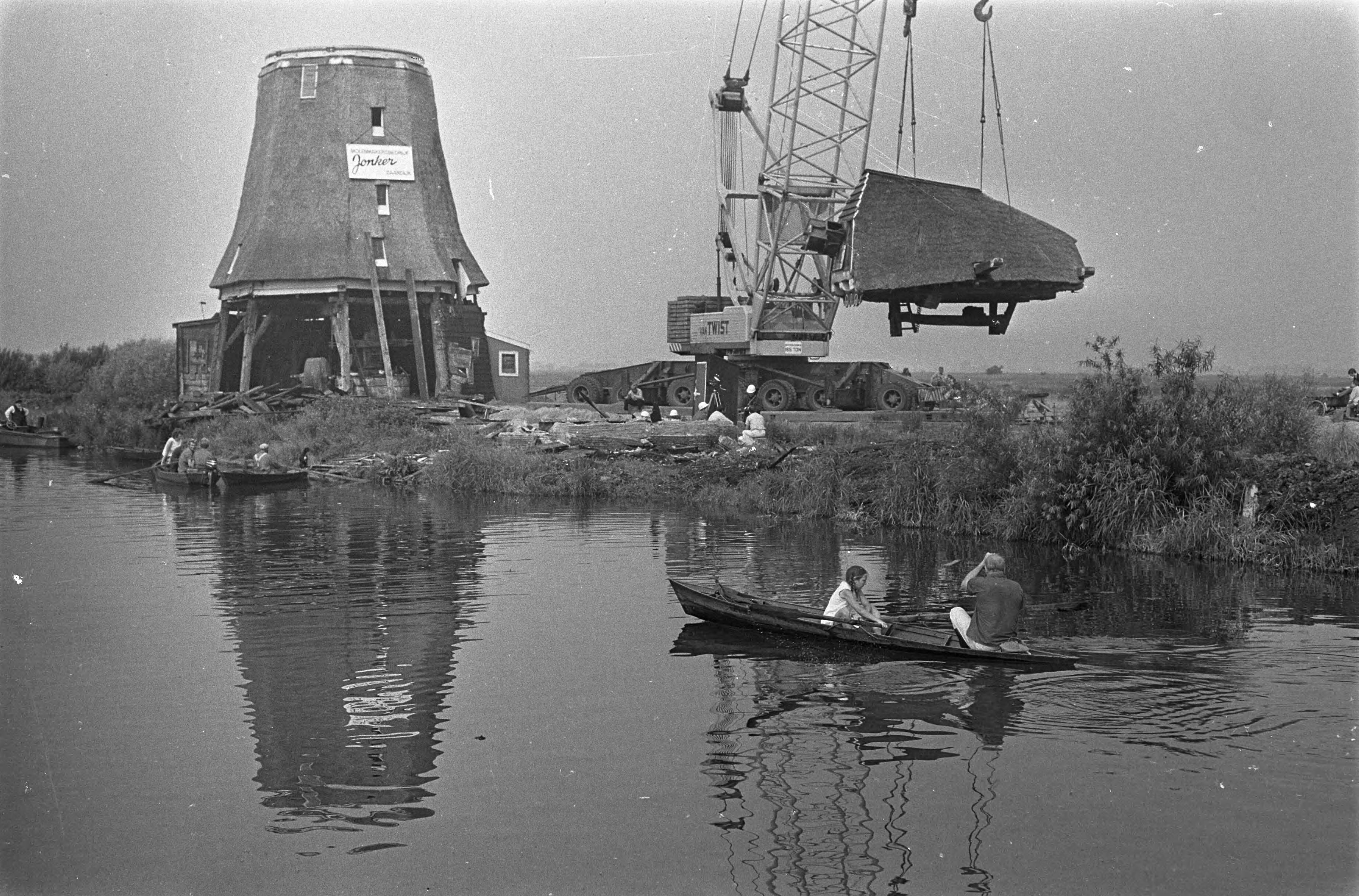 Verhuizing van de Zaanse oliemolen "de Zoeker" — Afname van de kop van de molen met behulp van een mobiele kraan — Foto: Fotograaf Onbekend / Anefo. Licentie: Set B: Rechtenvrij / Publiek Domein. Bron: Nationaal Archief. http://hdl.handle.net/10648/ab48bf12-d0b4-102d-bcf8-003048976d84