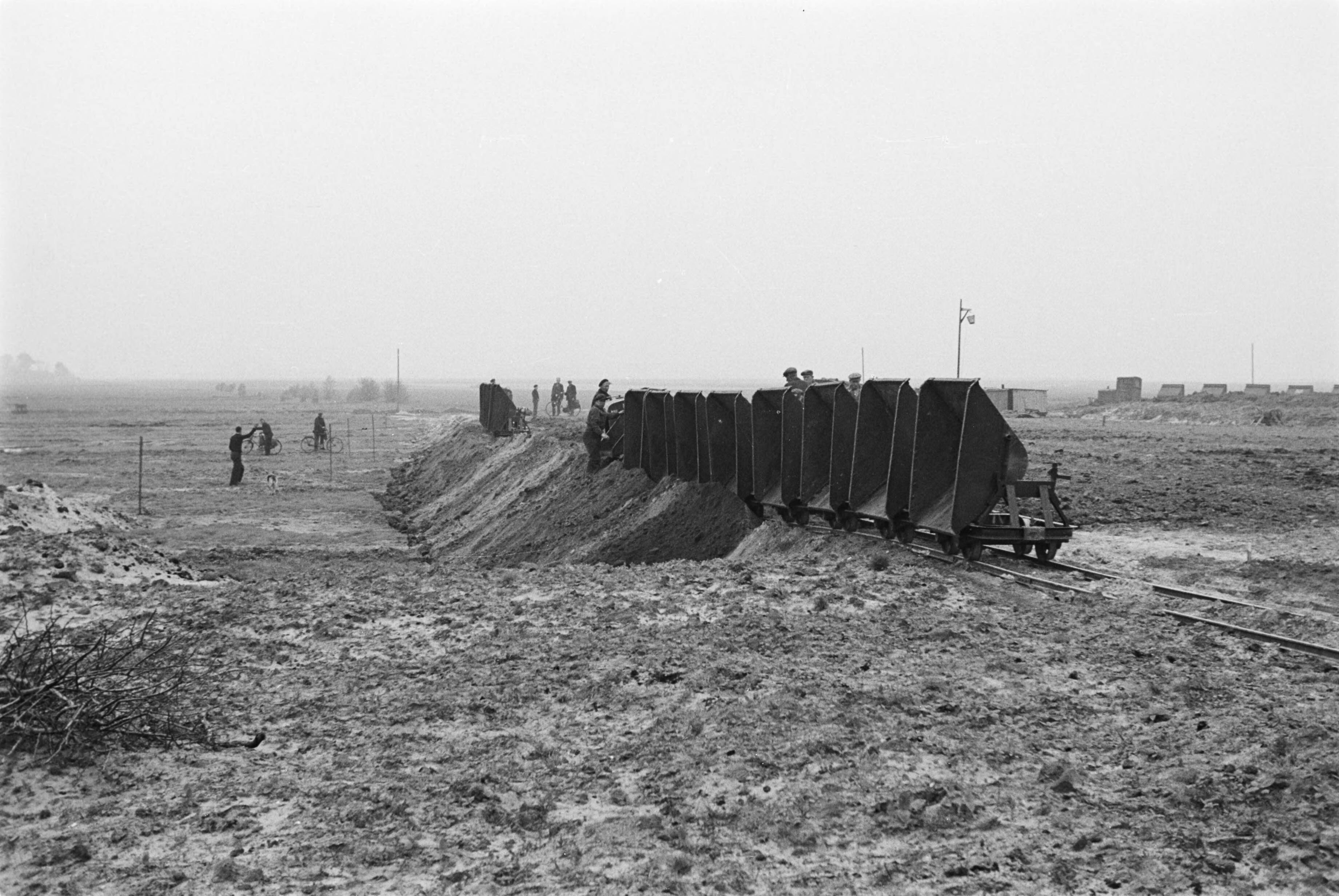 Fotocollectie Nederlandse Heidemaatschappij — Veendam|aanleg begraafplaats |arbeiders |werkzaamheden |zandvervoer |kipkarren|Groningen — Foto: Fotograaf Onbekend / Heidemij. Licentie: Set B: Rechtenvrij / Publiek Domein. Bron: Nationaal Archief. http://hdl.handle.net/10648/ae893b20-d0b4-102d-bcf8-003048976d84