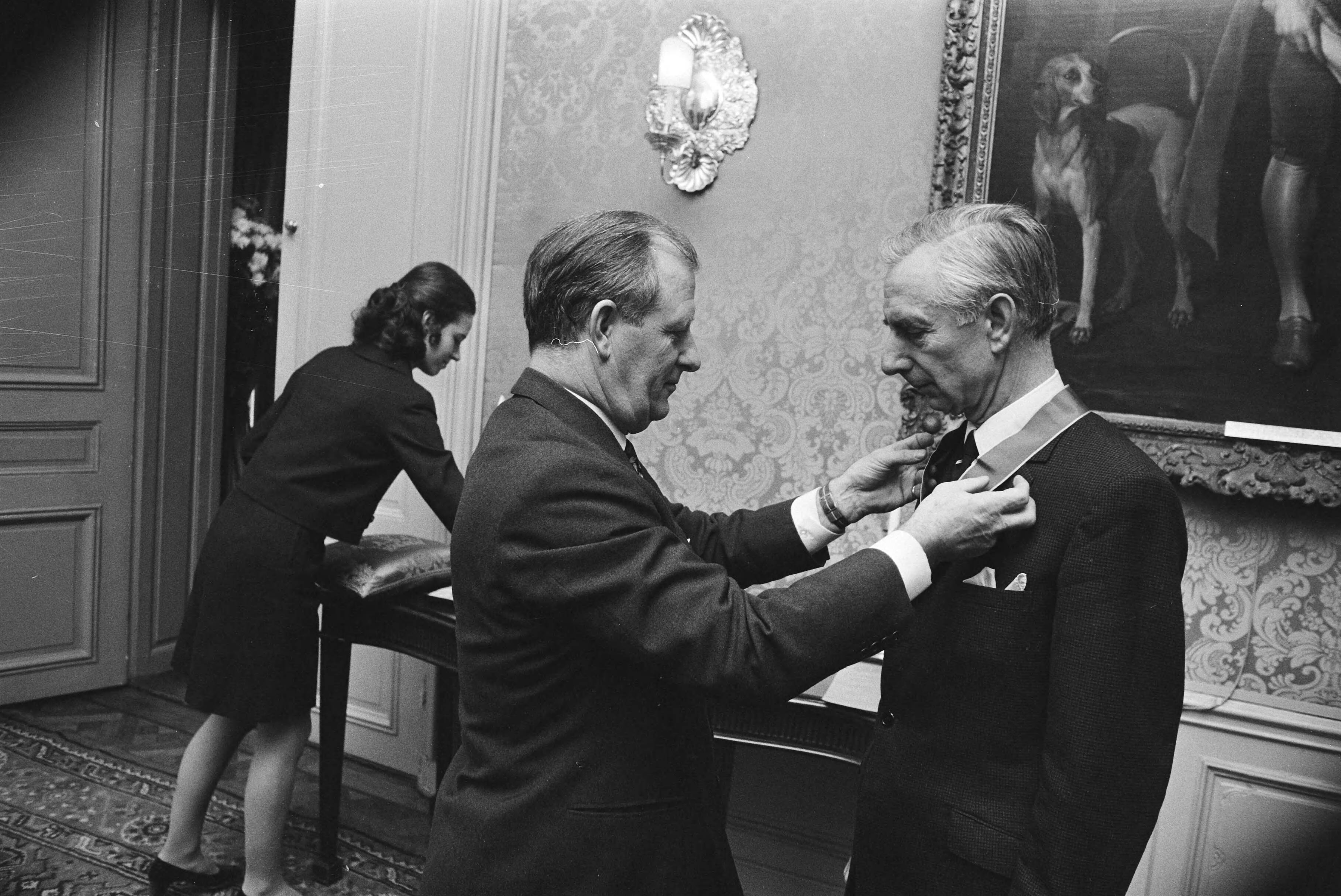 Fotocollectie Anefo — Britse ambassadeur reikt onderscheidingen uit op Ambassade Den Haag — Foto: Mieremet, Rob / Anefo. Licentie: Set B: Rechtenvrij / Publiek Domein. Bron: Nationaal Archief. http://hdl.handle.net/10648/abaadc92-d0b4-102d-bcf8-003048976d84