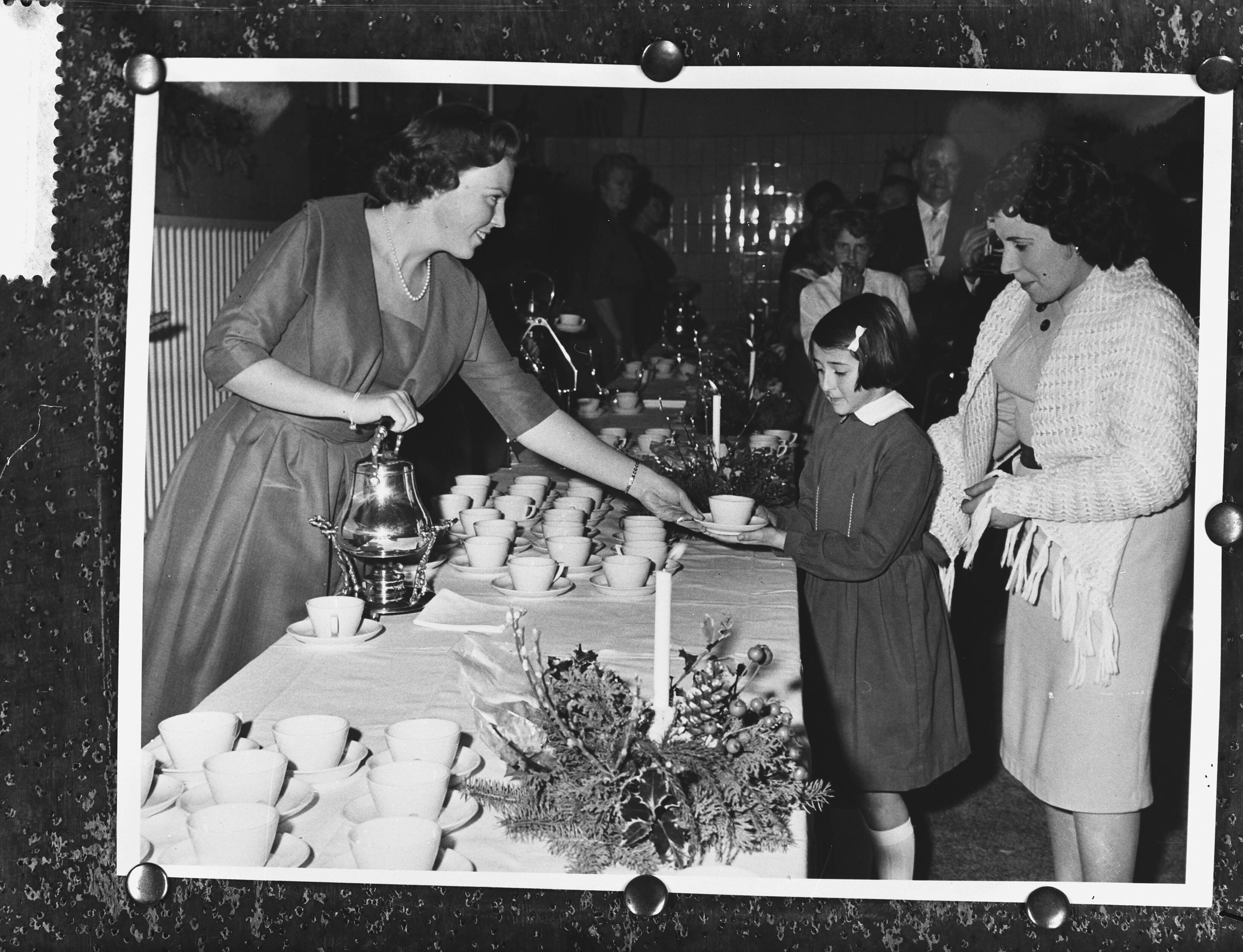 Fotocollectie Anefo — Kerstviering met koninklijke familie in het koetshuis van de koninklijke stallen in Den Haag. Prinses Beatrix deelt kopjes chocolademelk uit — Foto: Fotograaf Onbekend / Anefo. Licentie: Set B: Rechtenvrij / Publiek Domein. Bron: Nationaal Archief. http://hdl.handle.net/10648/a9a43e16-d0b4-102d-bcf8-003048976d84